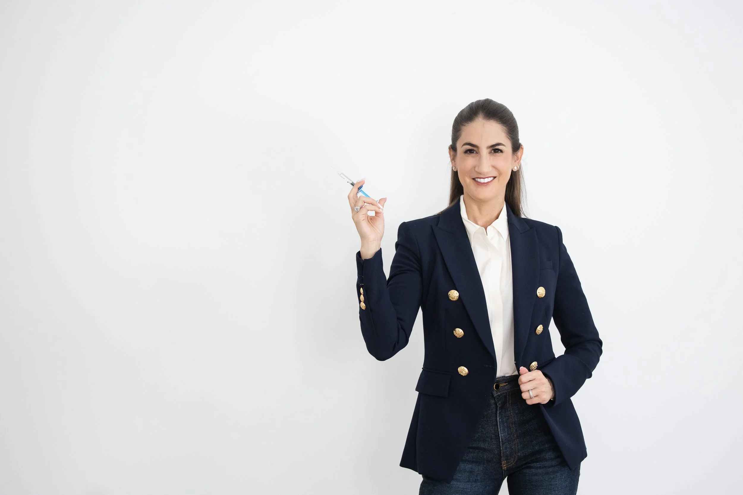 women standing holding a injector needle with a plain white background