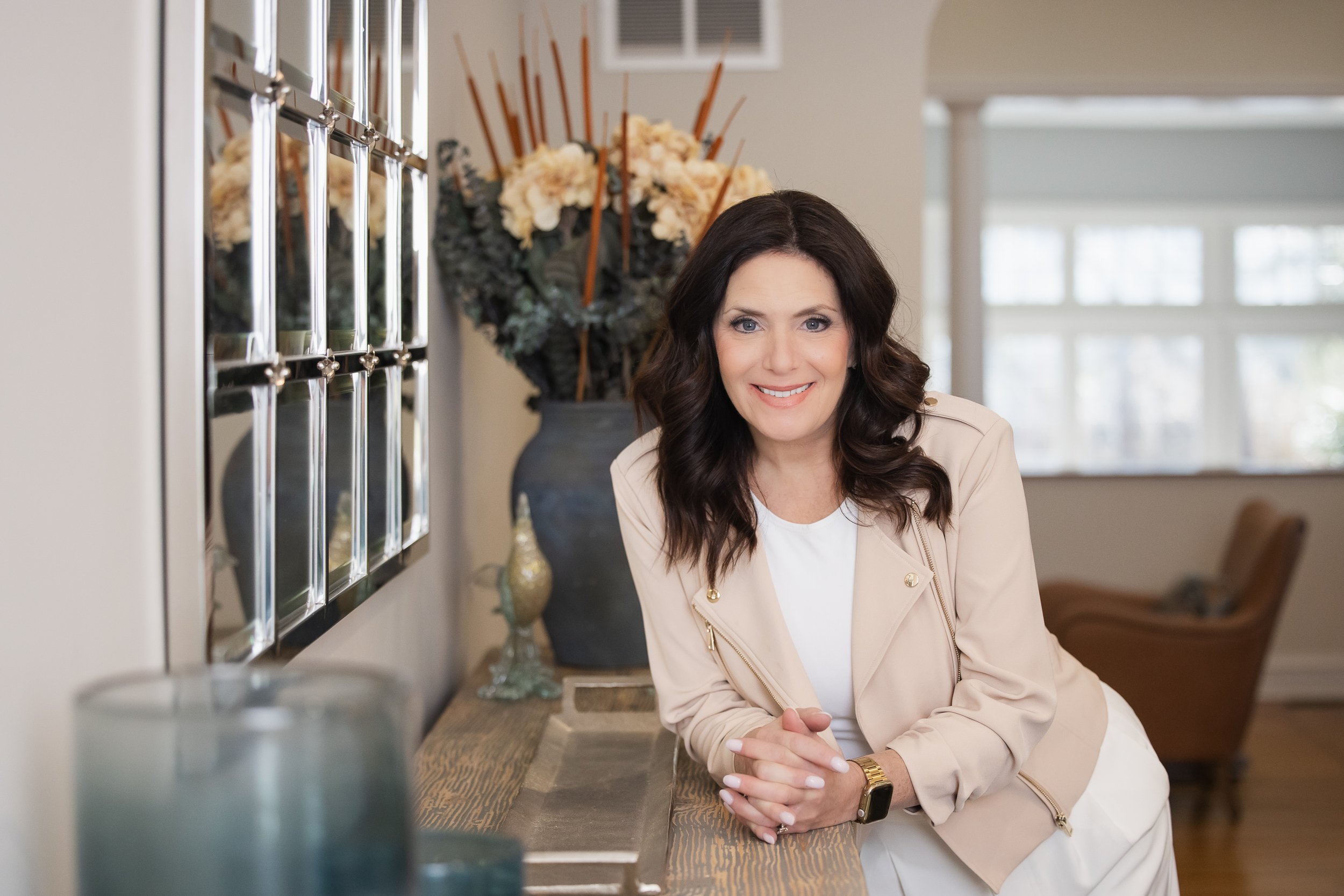 lifestyle brand image of a female interior designer leaning against sideboard