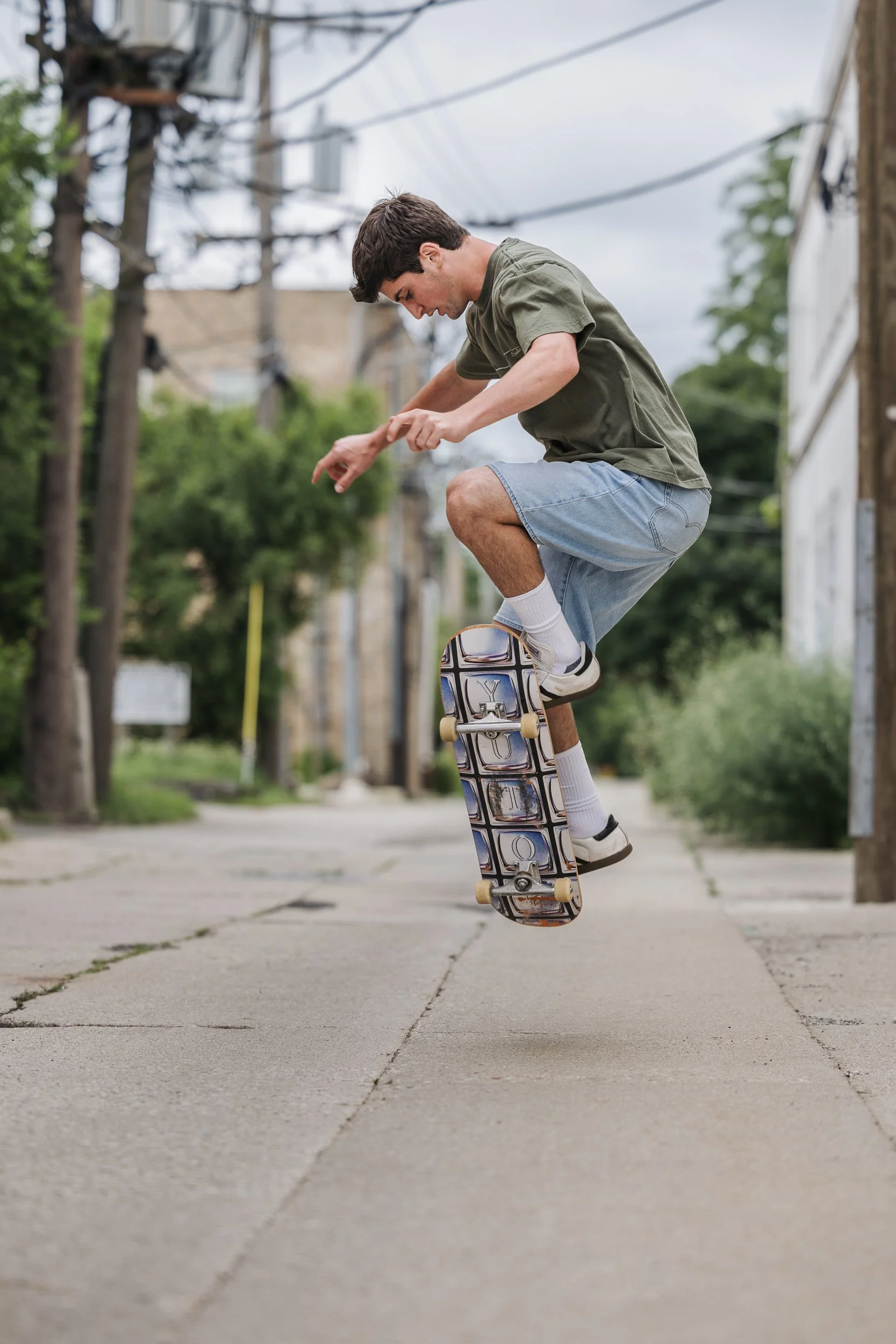 teen boy doing a trick on a skateboard in an urban alley