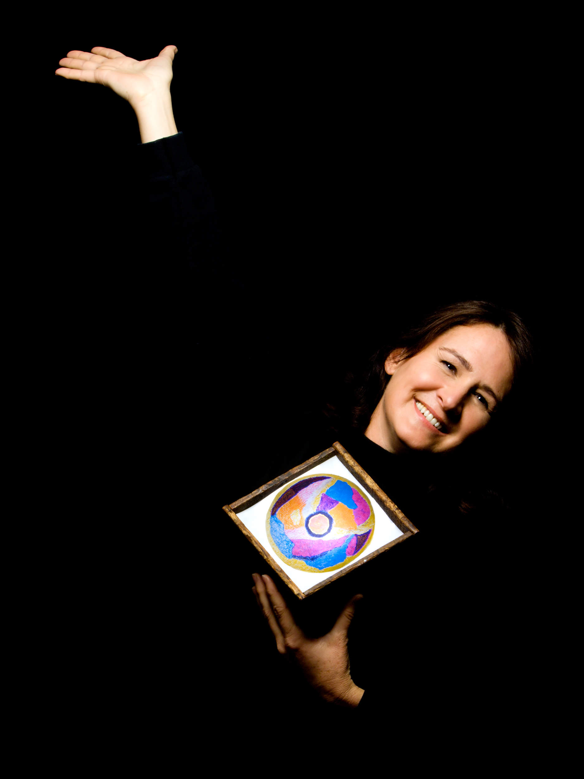 “It always comes back to the same necessity: go deep enough and there is a bedrock of truth, however hard.” ~ May Sarton. I have been in the process of integrating all aspects of myself: emotions, intellect, spirit and body. Participating in the Revealed project clarifies this integration experience for me by providing an outer expression of what has been going on inside for a long time. My journey through life began with a magnitude of loss, grief, disappointment and anger at the severe and unfair events of my childhood. Over time, I learned to recognize and trust my spirit, intuitively guiding me beyond my shattered and fragmented self ~ into my poet soul. Like a miner discovering veins in a gold mine, I uncovered secret treasures while in the darkness. In Sanskrit, mandala means sacred circle ~ representing something eternal ~ with no beginning and no end. A light inside my box illuminates a mandala, creating a stained- glass window effect. I painted this mandala in order to see and experience aspects of myself that I had hidden and disowned. In the end, I found a sense of self made visible, an experience of self-care and compassion; a fusing together of the fragmented parts of myself ~ restoring me toward wholeness and connection to a sense of the eternal. Annie S. Lawrence, Kansas 2006