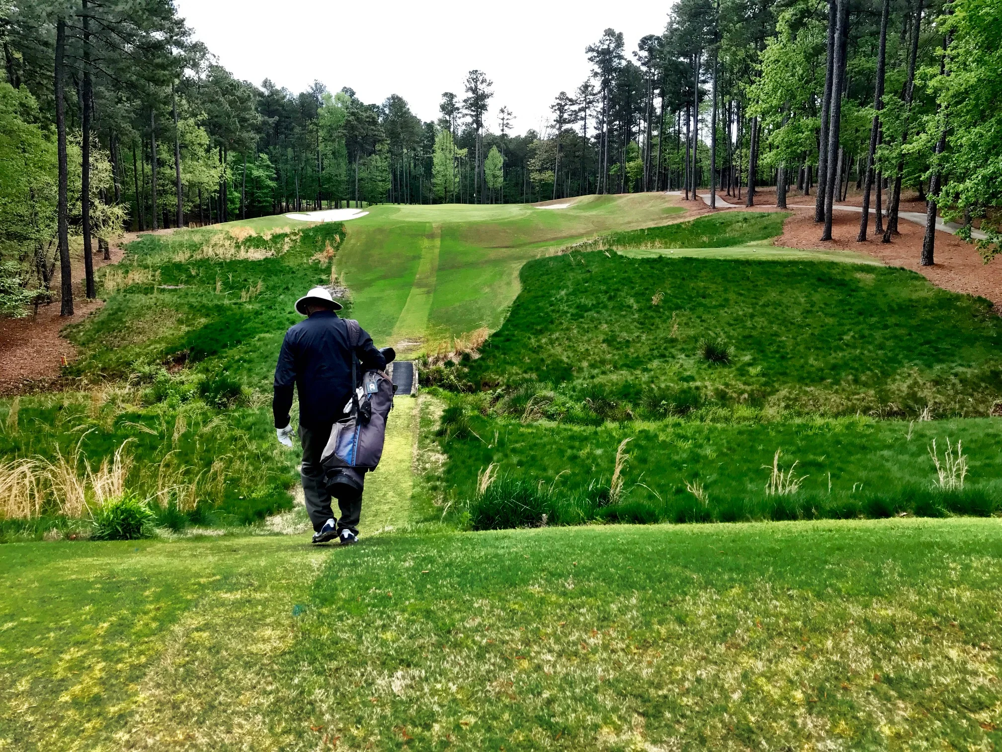 Howard Lee walking off the seventh tee down one of the paths maintained for the benefit of walkers. "I just think as long as someone my age can walk, it would be a sin not to do it," Lee says.