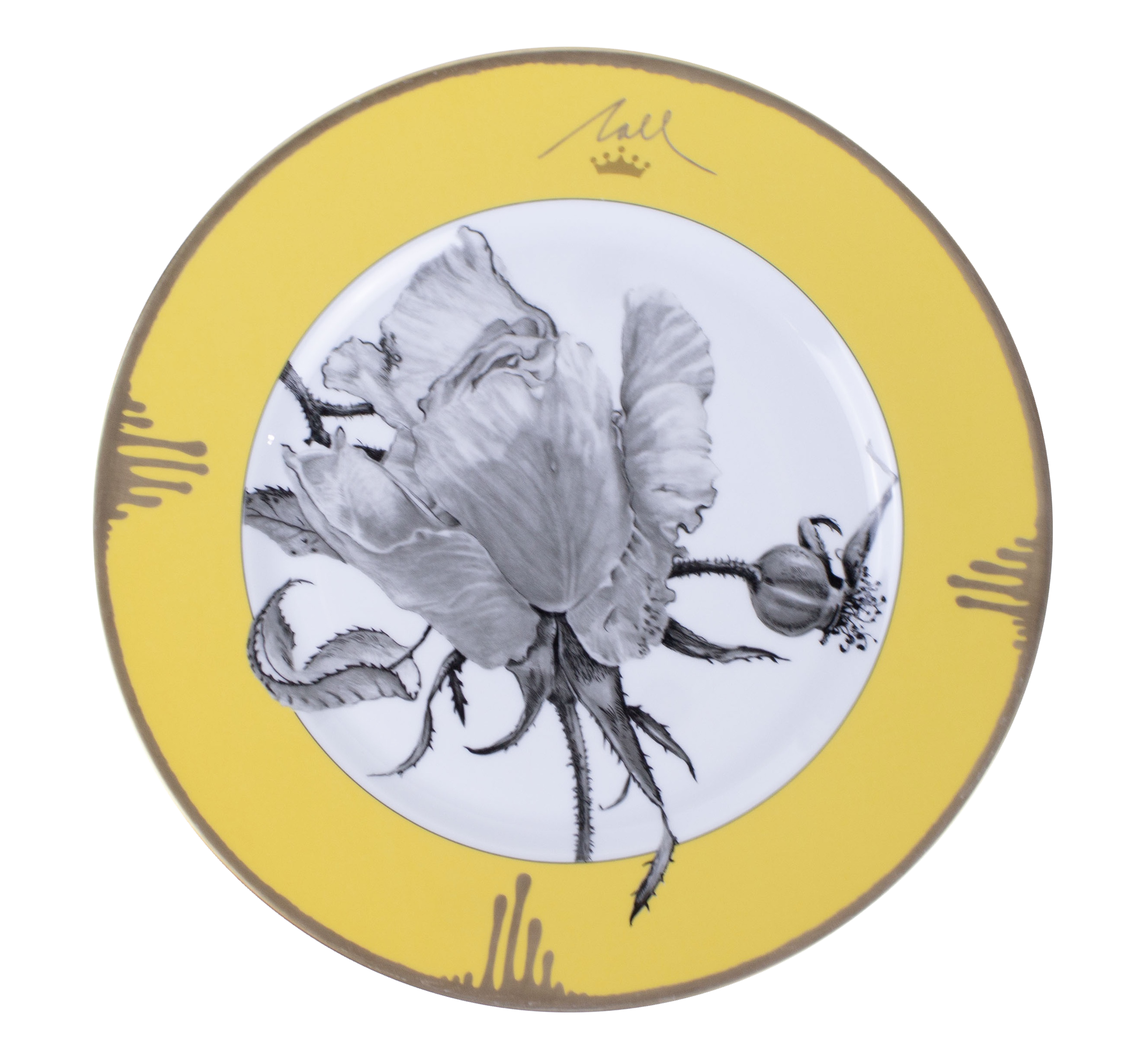Close-up of a decorative ceramic plate with a botanical illustration of a flower and leaves, featuring a yellow border with handwritten text and a crown symbol.