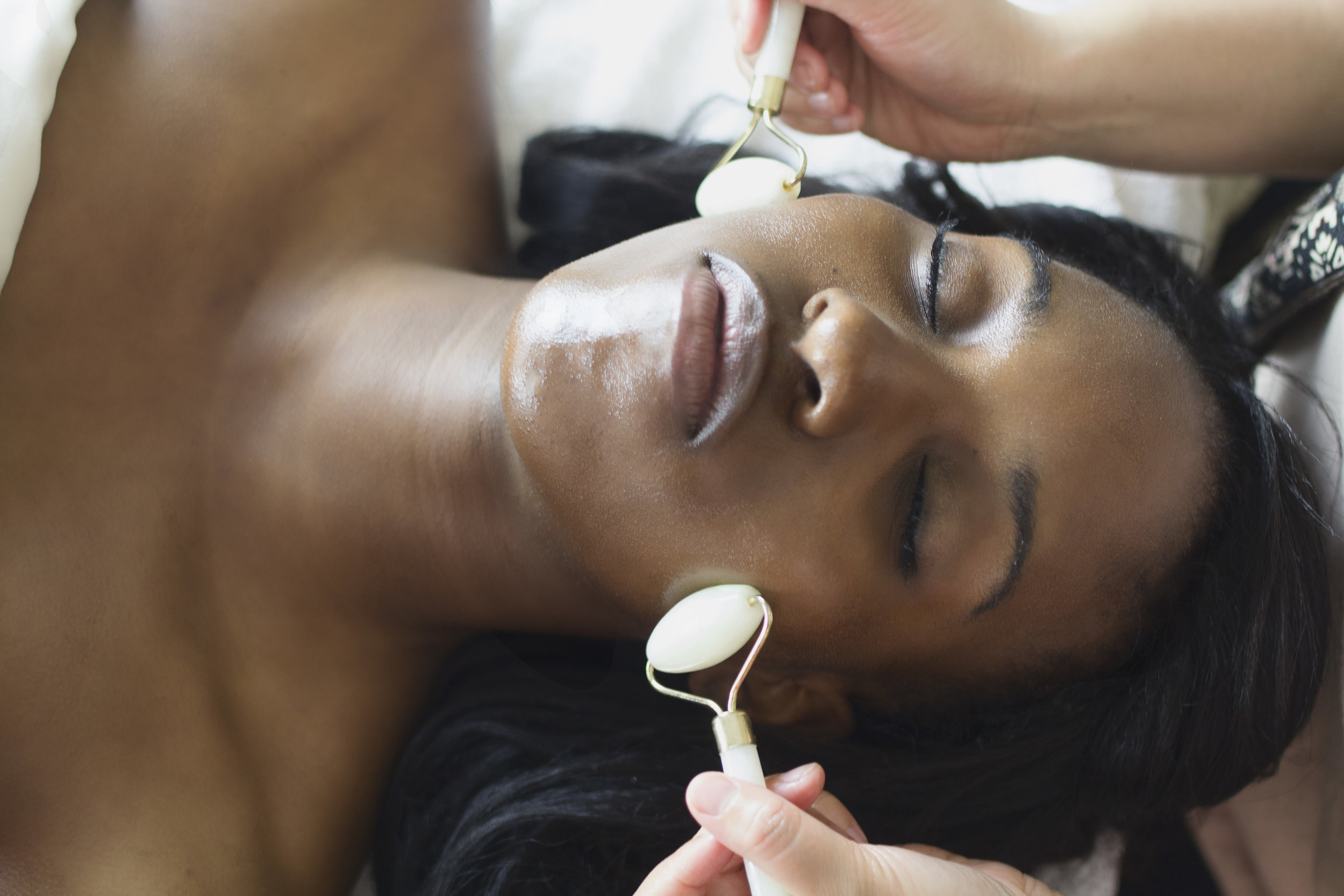 Black woman receiving a jade roller facial massage at Jalan Spa