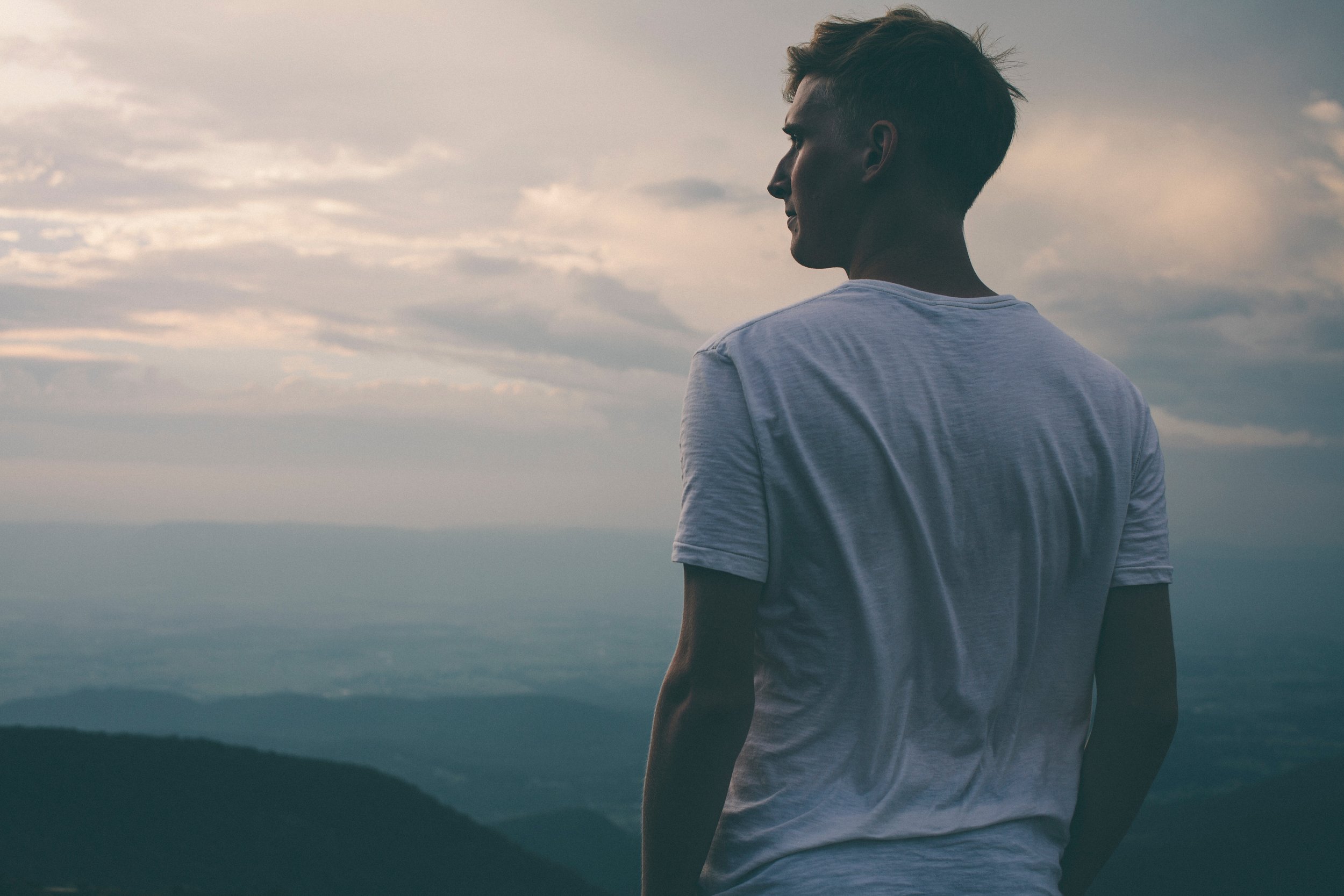 Man overlooking the mountains at sunset