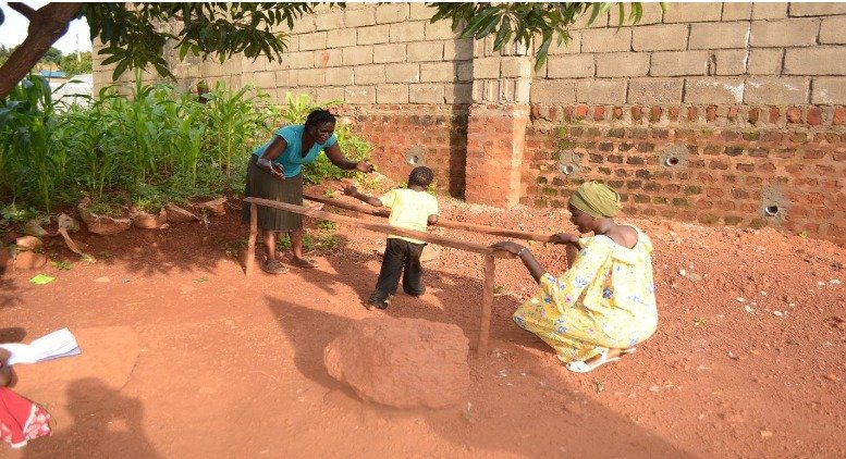 The caregivers at Home of Hope give their all for the children.  Here, one of the women demonstrates how a child uses the parallel bars she made for him.