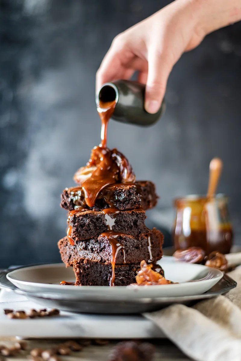 Pouring caramel over warm brownies
