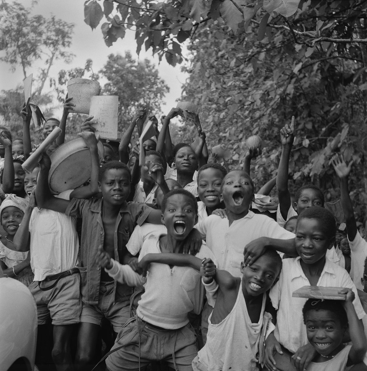  Todd Webb (United States, 1905-2000),  Untitled (44UN-T3-R1-001), Togoland (Togo)  [Excited group of children with their school books and bags] ,  1958, archival pigment print, 20 x 20 inches (image), 22 x 22 inches (sheet). © Todd Webb Archive 