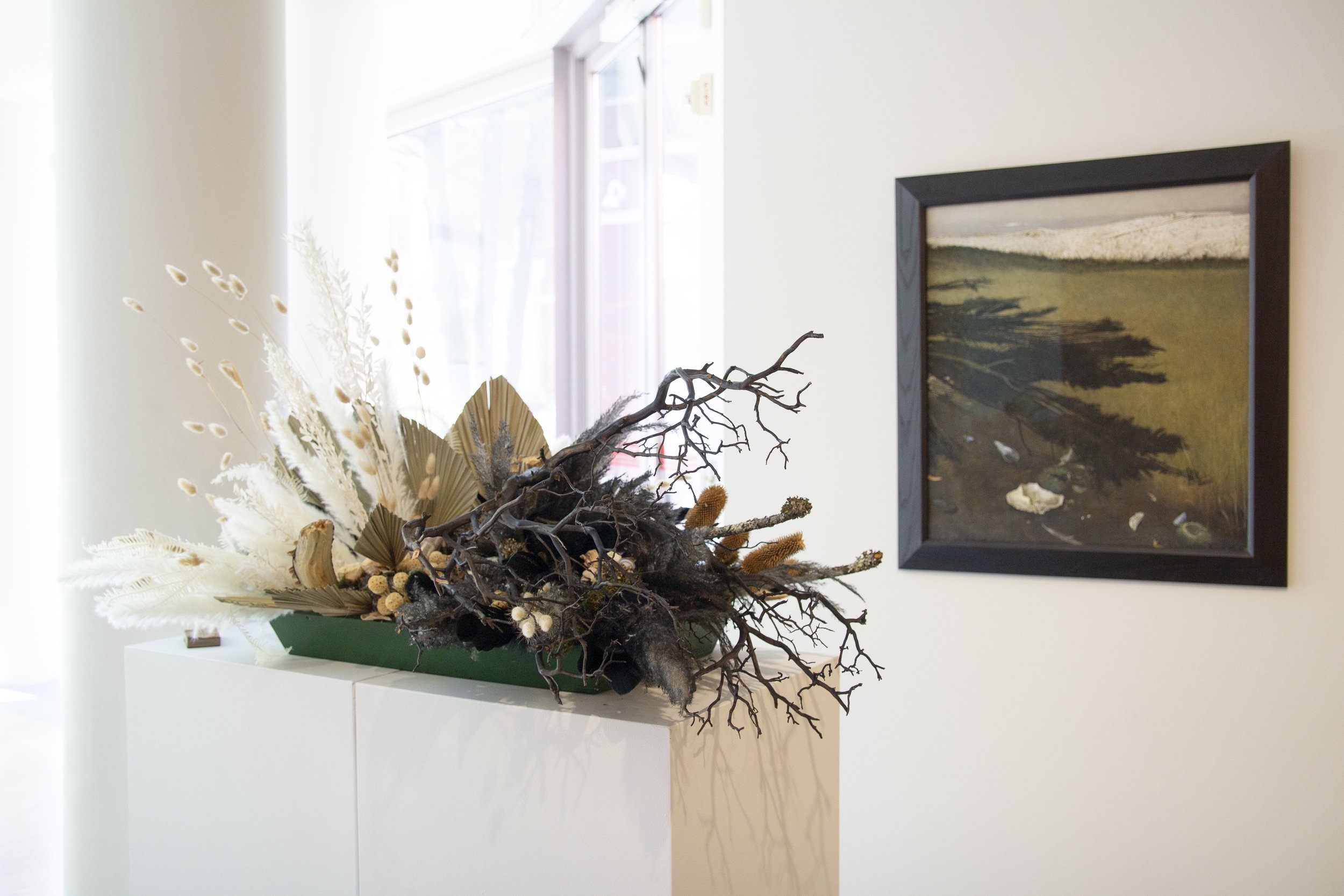   Marcia Davis Flowers, Migis Hospitality Group    Inspiration :  Raven's Grove  by Andrew Wyeth   Materials:  Roses, feathers, italian ruscus, pods, clam shells, lichen, moss, branches, preserved mushrooms, craspedia, turkey tail, palms, pampas gras