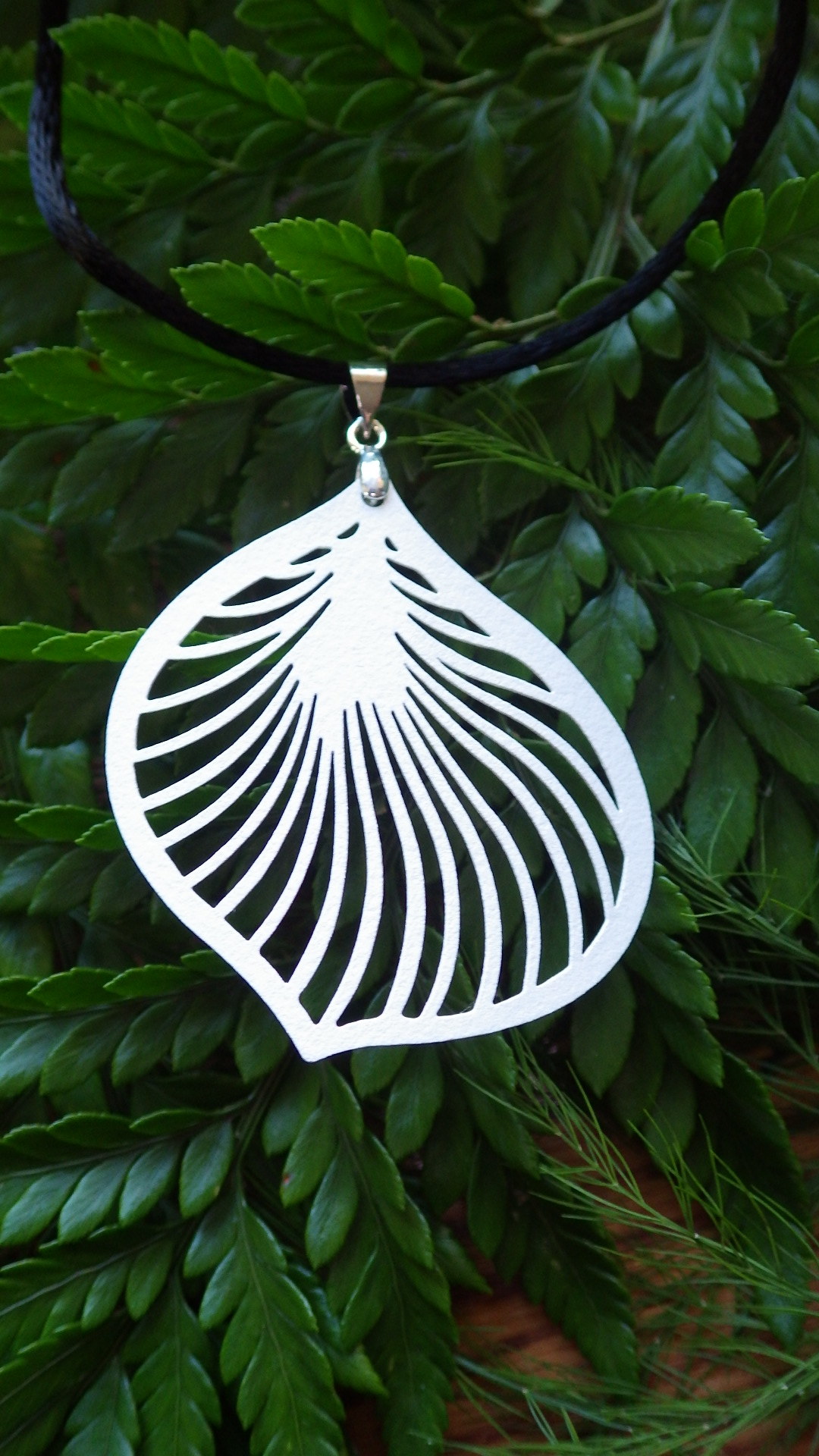  White filigree (brass metal stamping) on black cord with a silver clasp  18”  $19.95 