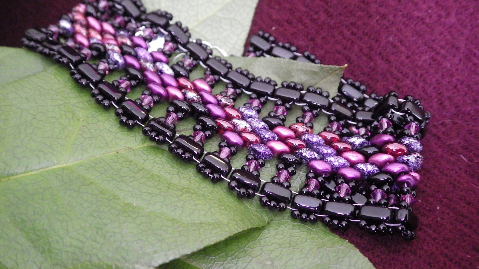  Seed  bead bracelet - Black edge, black fringe, purples/red/pink inside with silver findings  8.5”  $45.00 