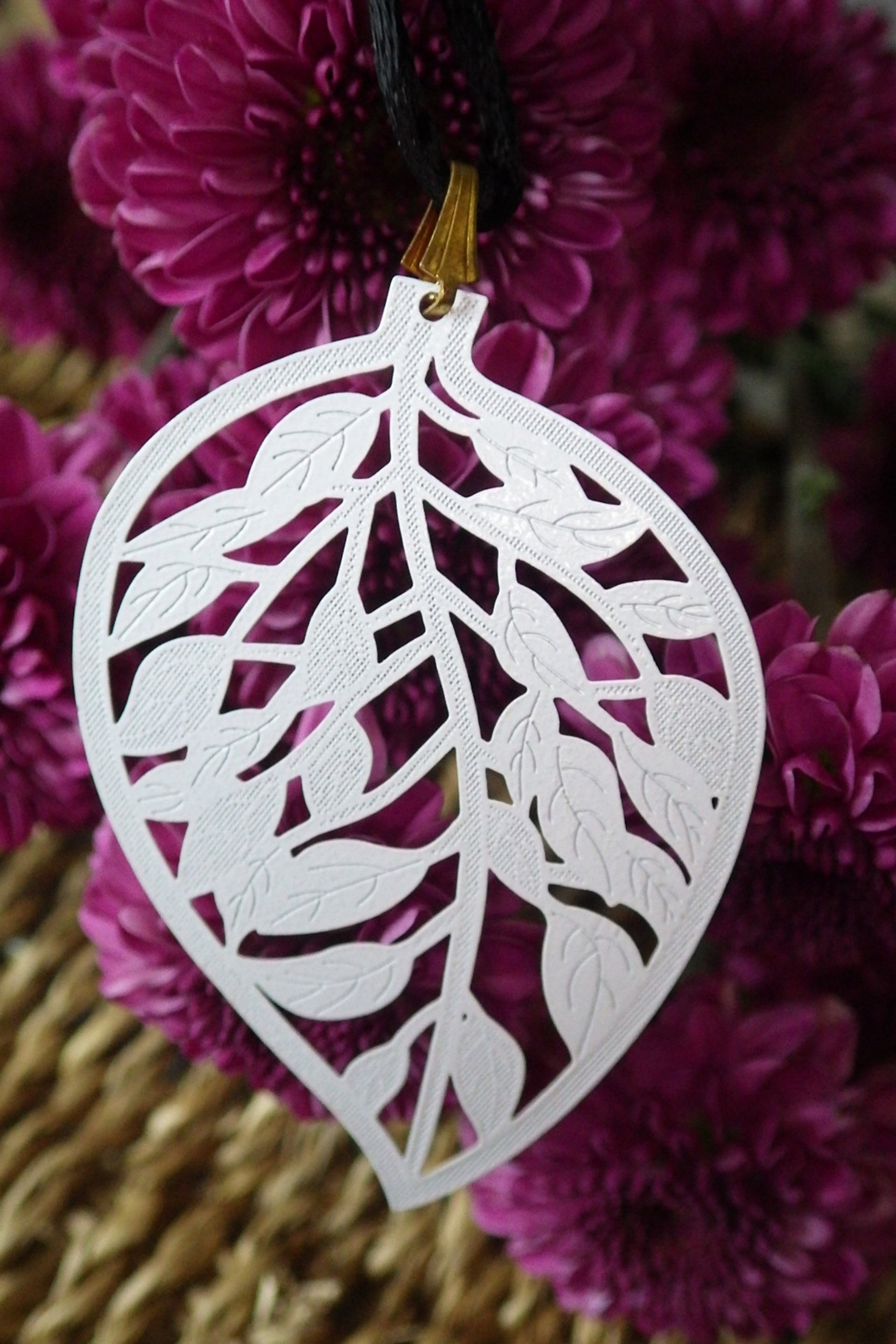  White leaf (brass metal stamping), black cord and gold findings  18”  $19.95 