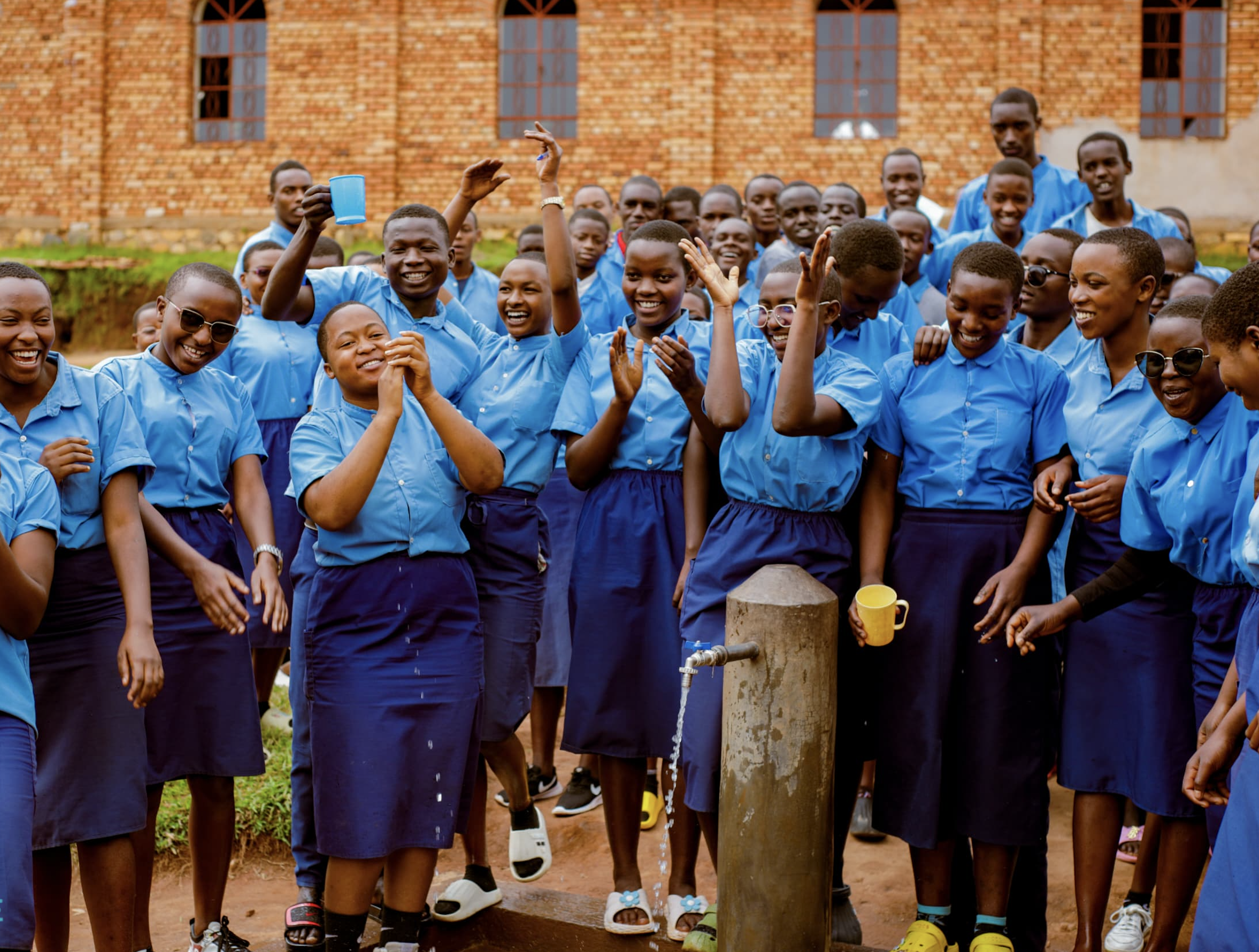 School children celebrate the arrival of a clean water tap near their school.