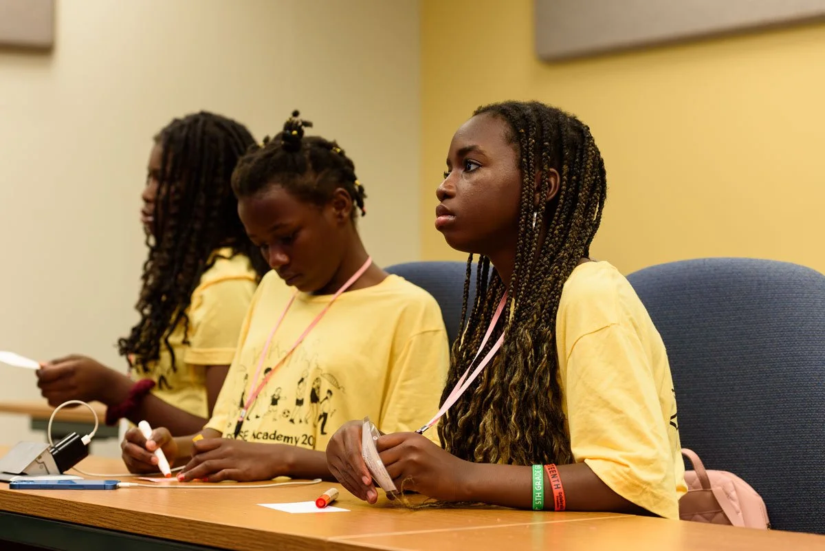 Three students sitting in classroom learning during PRYSE