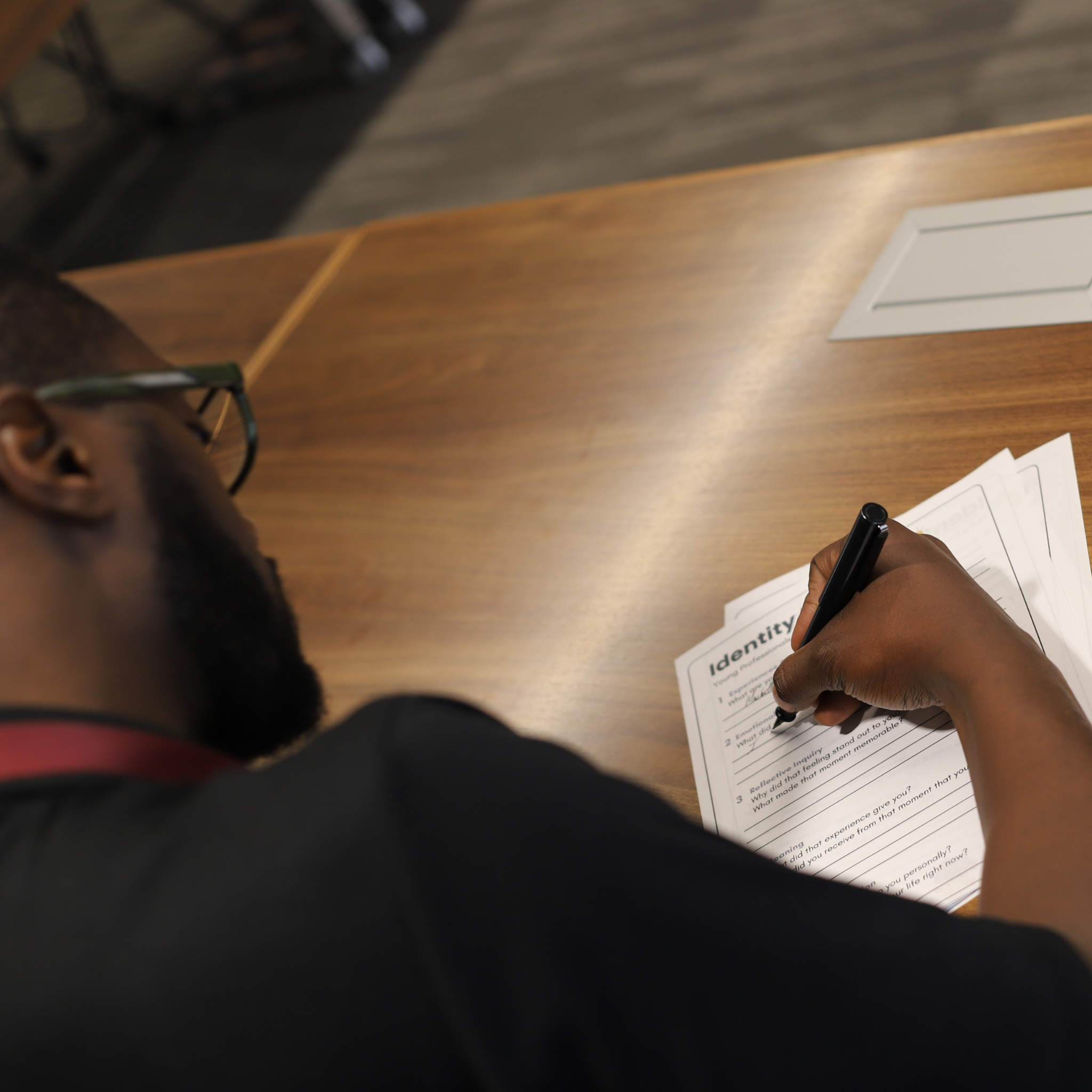 Attendee writing on a handout titled "Identity"