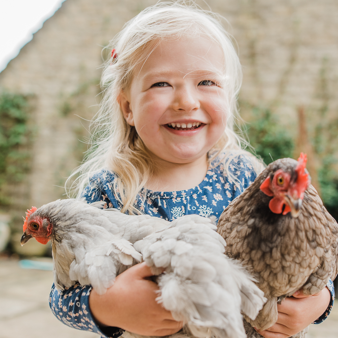 Little Girl hugging chickens Cheltenham Child Photographer.jpg
