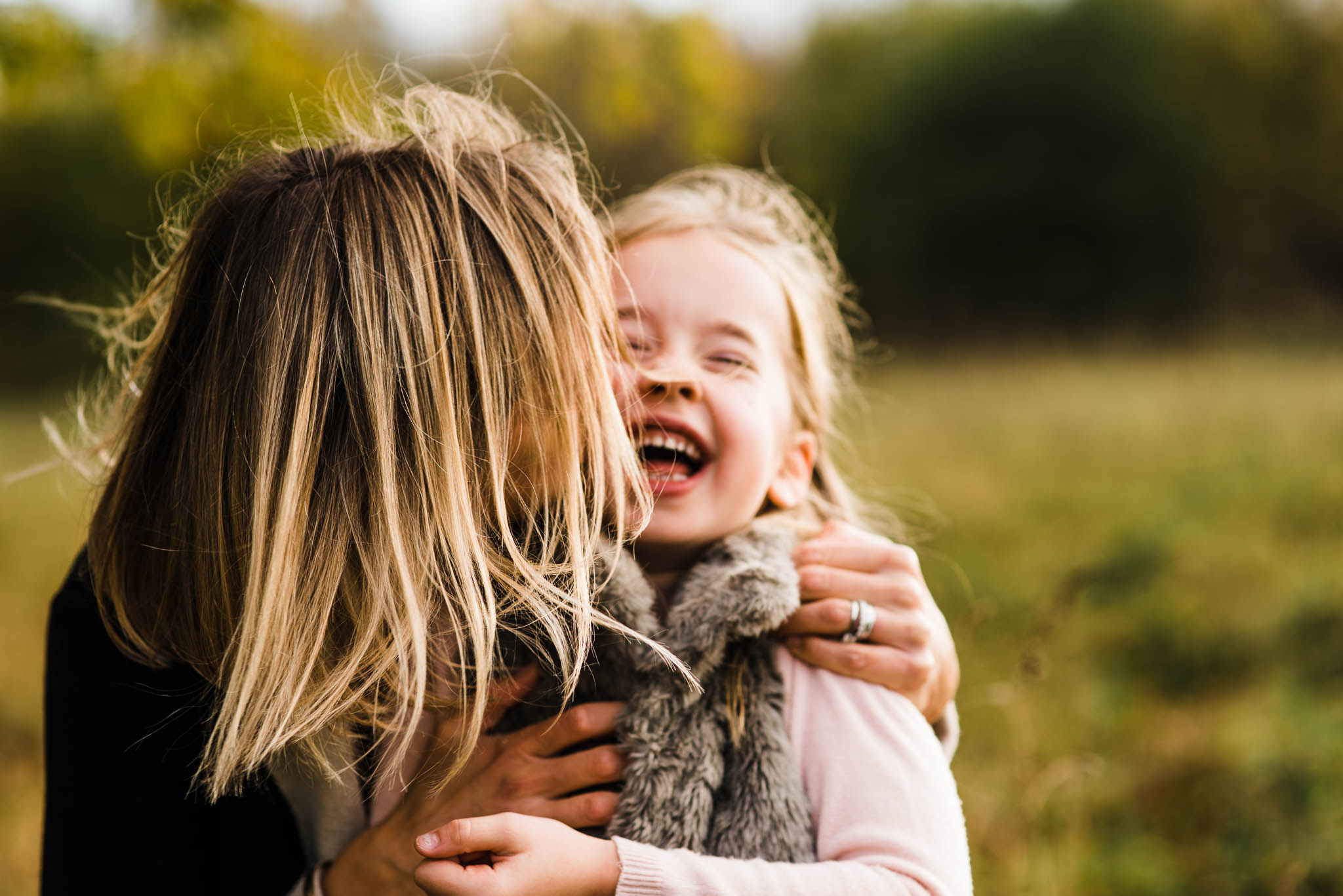 Little girl and mother laughing and cuddling in field Cheltenham.jpg