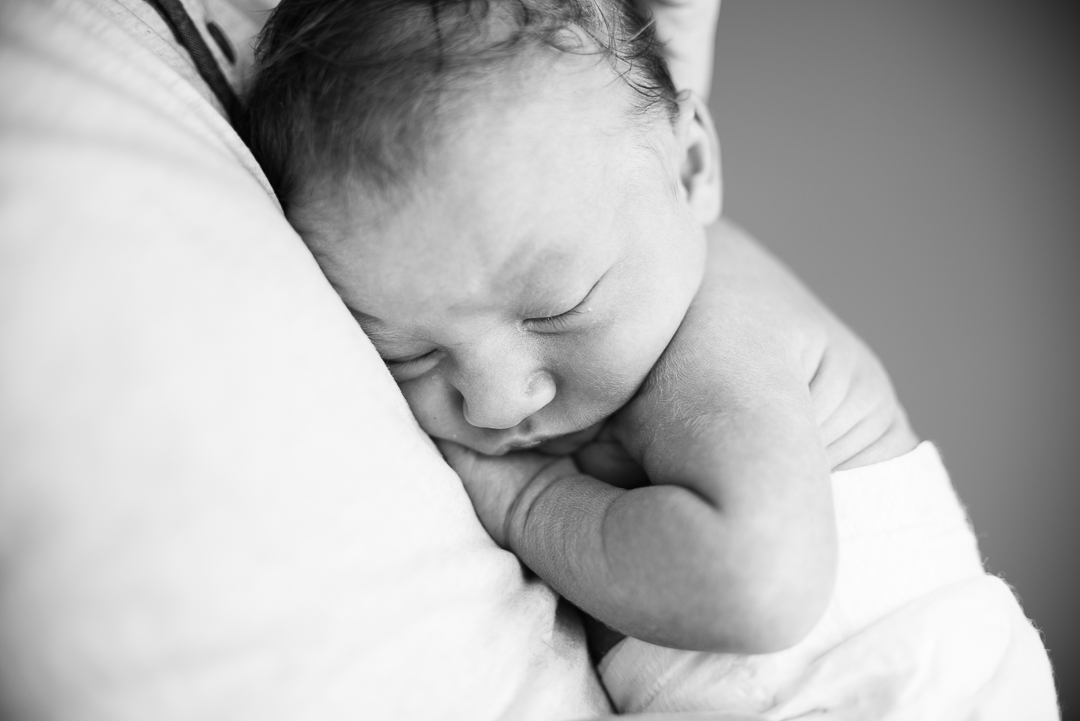 Newborn baby sleeping in daddy's arms Cheltenham Photographer.jpg