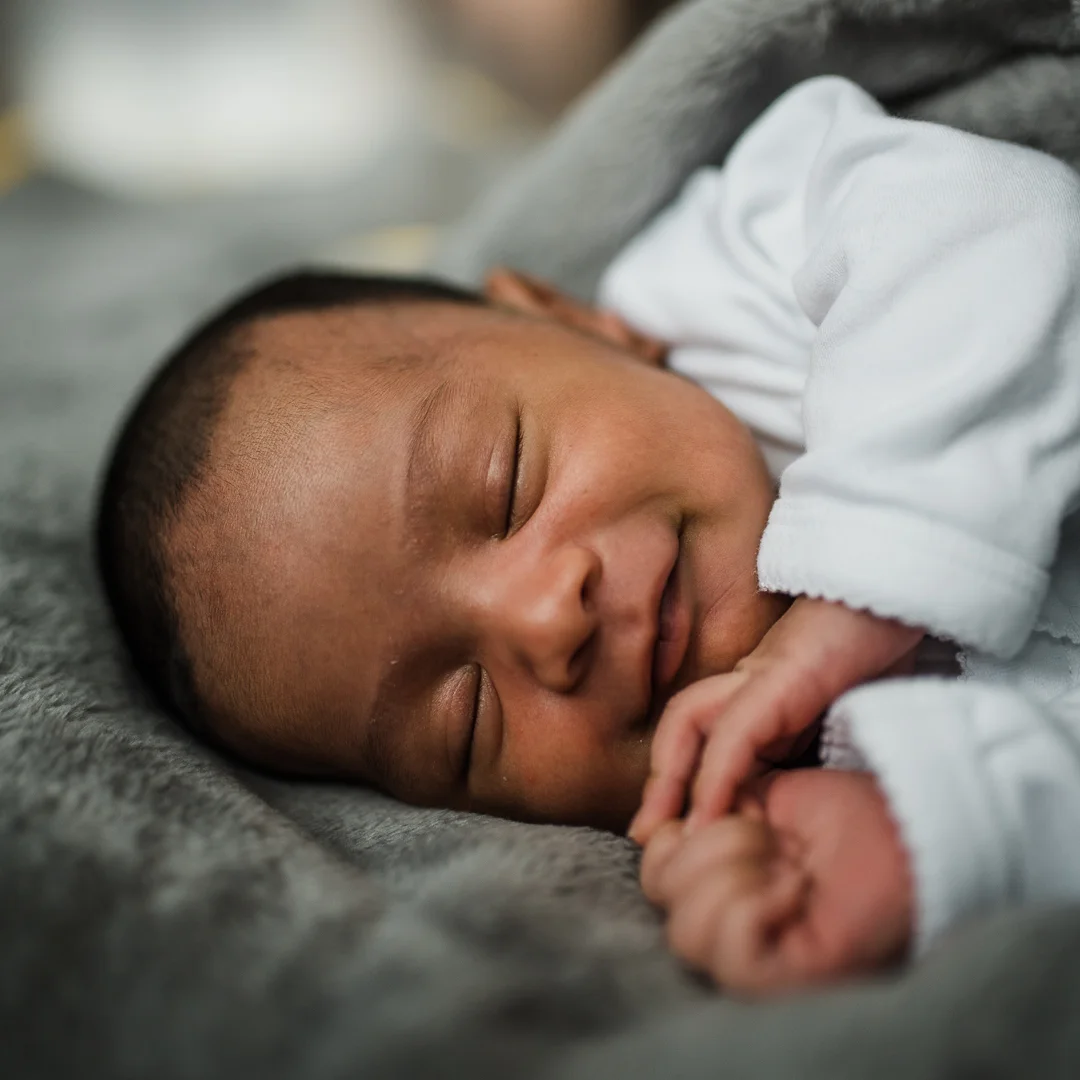 Smiling sleeping newborn baby cheltenham.jpg