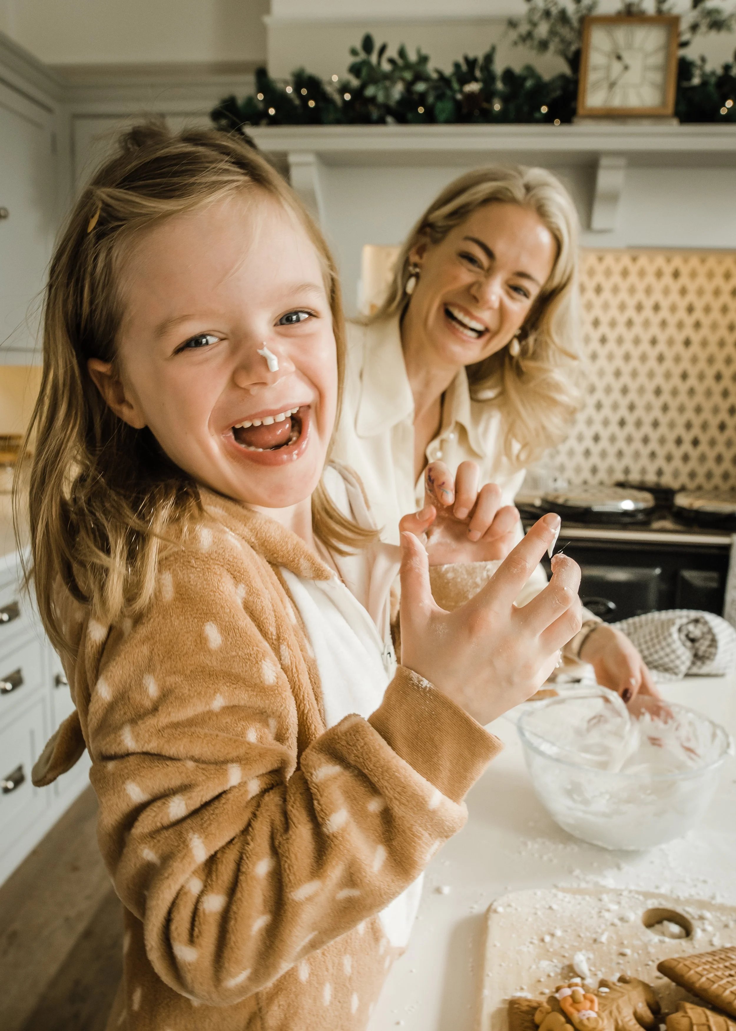Photo of Mother and Daughter having fun I the kitchen baking