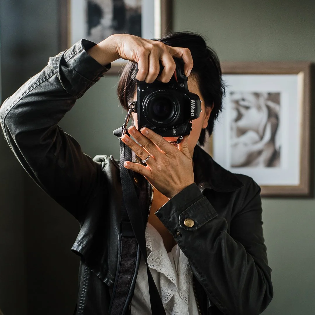 Female photographer preparing her camera for a natural light portrait session.