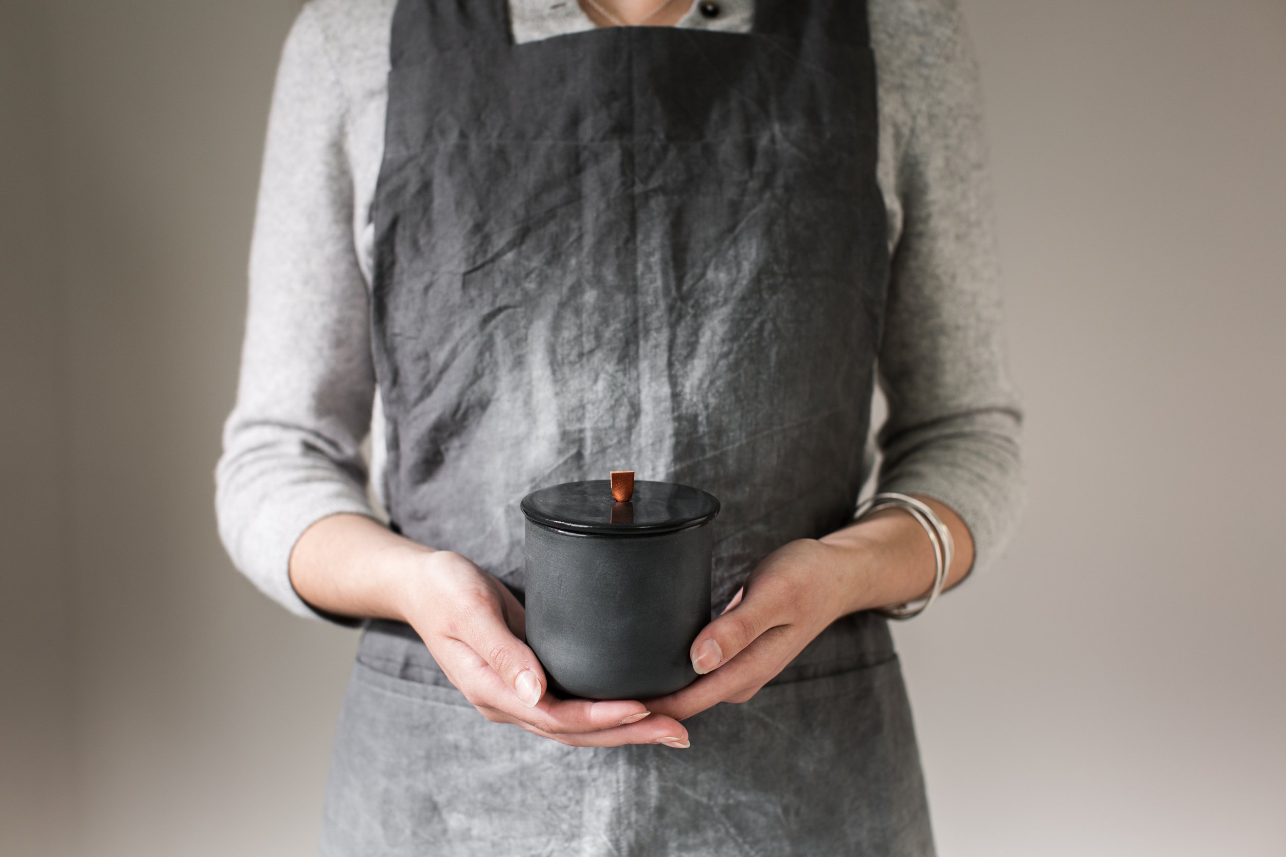 Pippi Me Cermaics- Dark Grey Earthenware- Beaker with lid being held.jpeg
