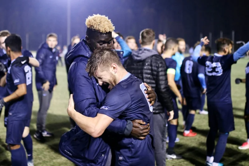 An emotional Cam Lindley (right) hugs teammate Prince Agyie (left) after the final whistle
