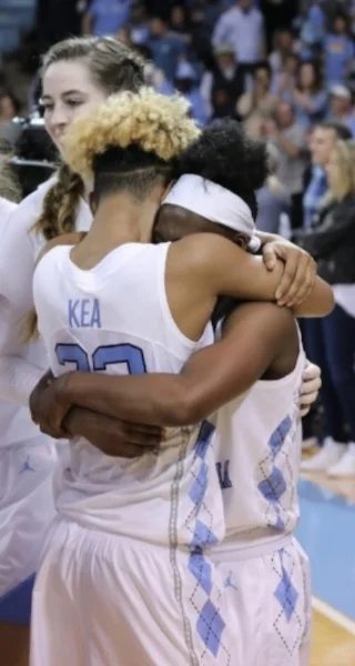 Paris Kea (22) and Jamie Cherry (10) embrace after Sunday's overtime win over Duke. | Photo by Caleb Jones