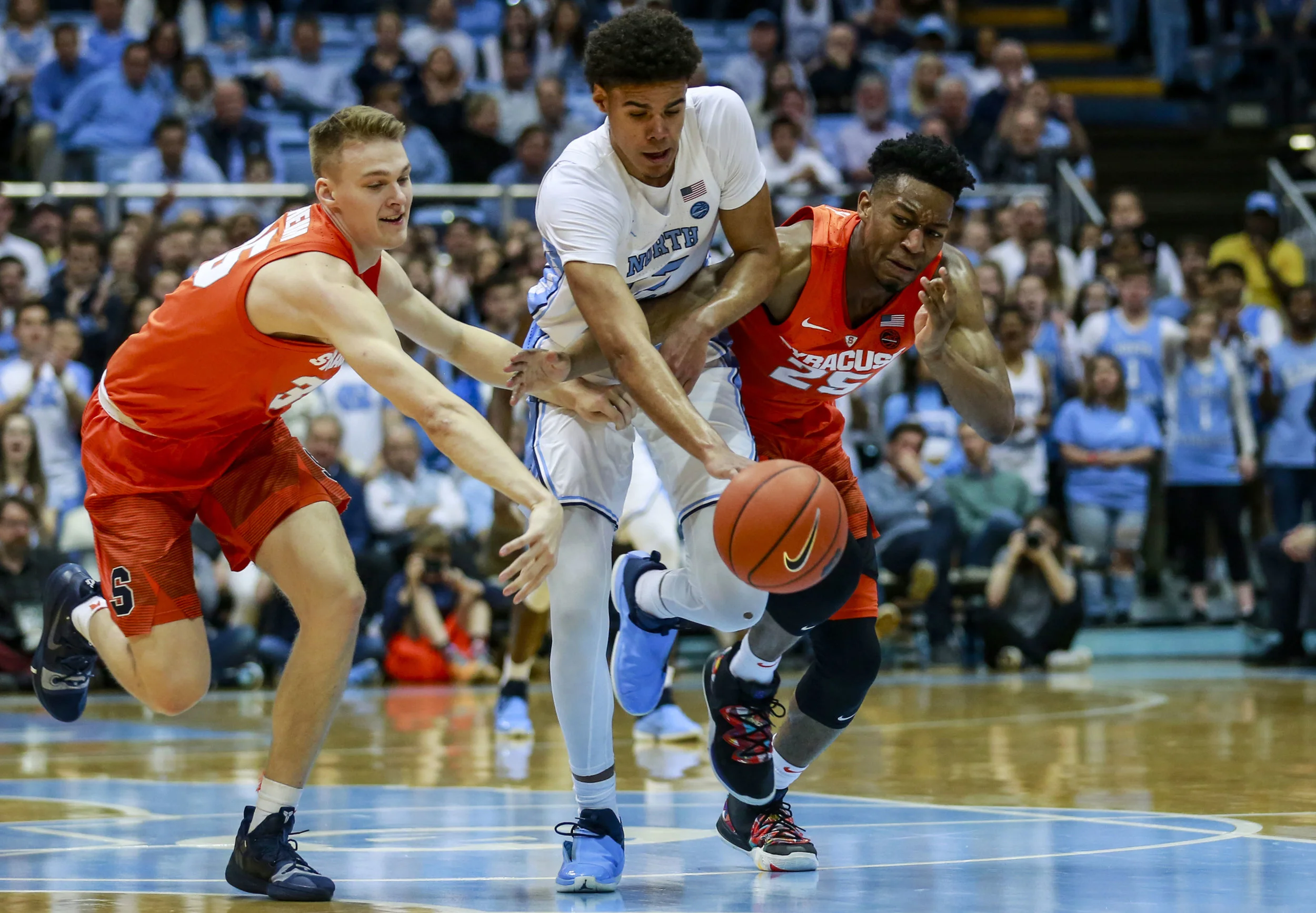 Cameron Johnson gets harassed at the top of the key by two Syracuse defenders. The high guard pressure is key for a 2-3 defense both Syracuse and Washington run to be effective. | Photo by Alex Kormann
