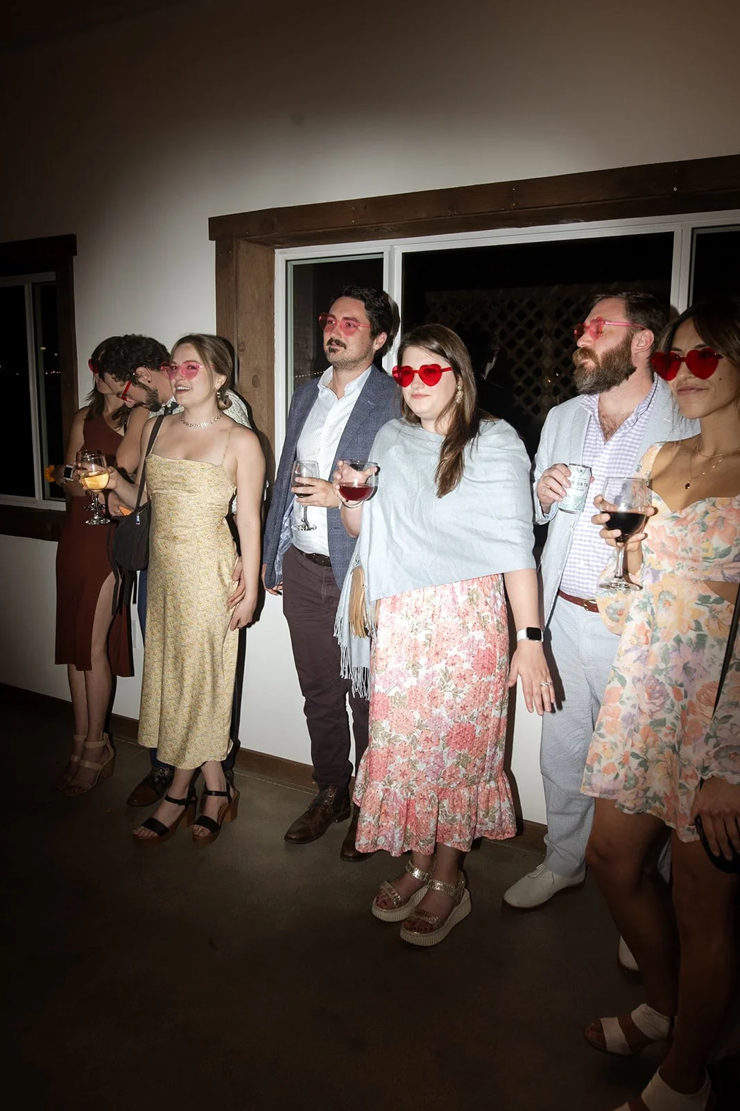Wedding guests wearing heart-shaped sunglasses on the dance floor