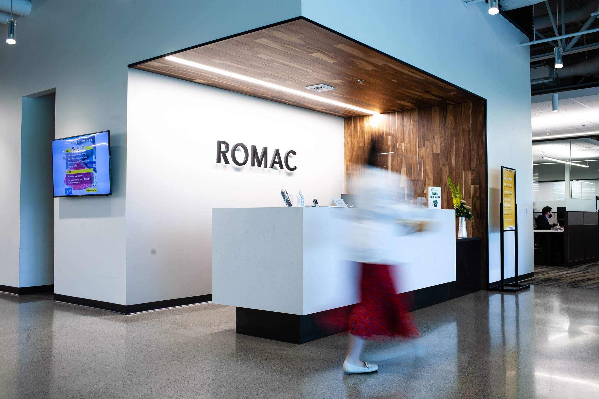 romac-industries-inc-home-office-front-desk-walking-person-blur.jpg