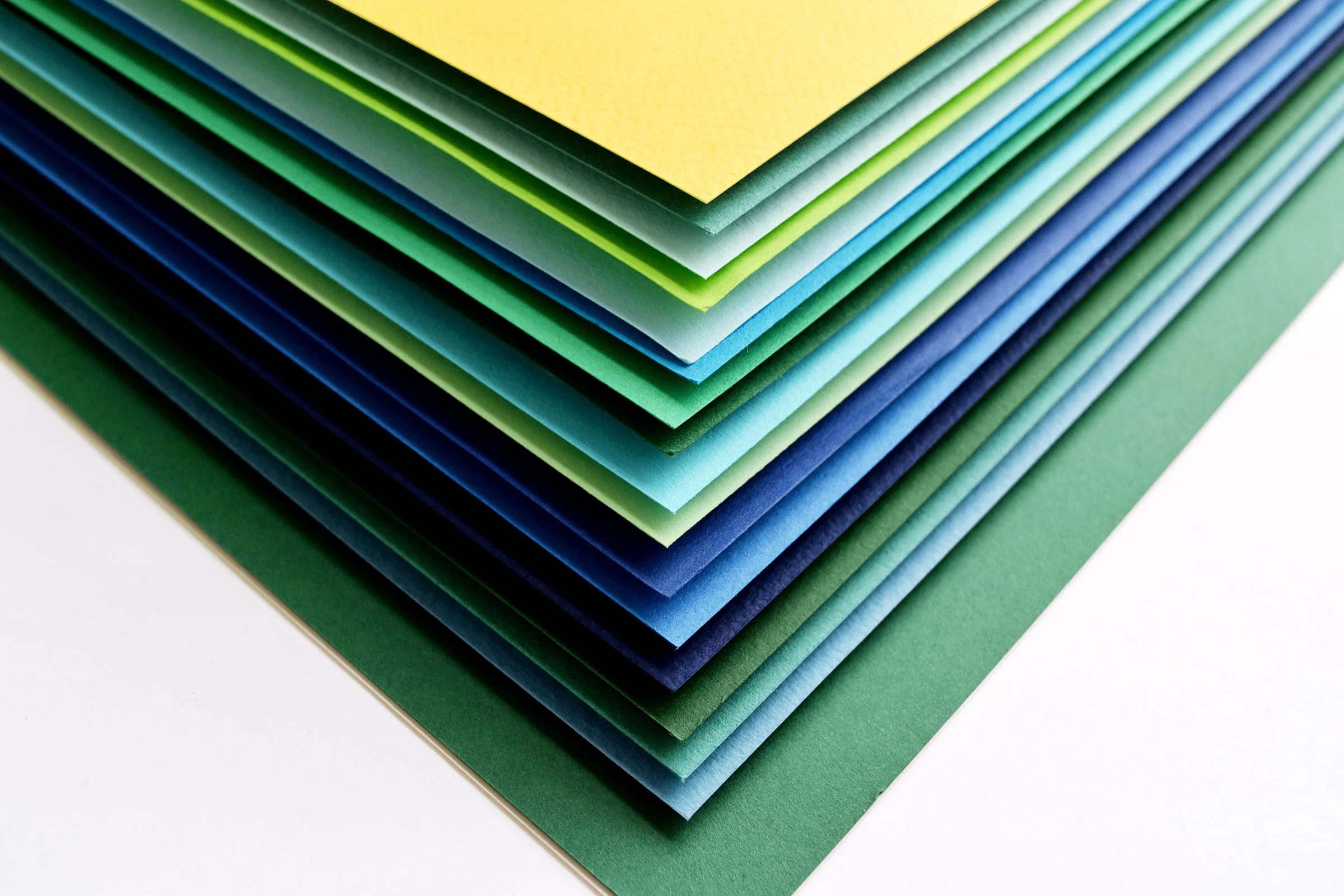 Once all the papers are cut, he stacks them using foam core or cardboard as spacers to give the cutouts depth.