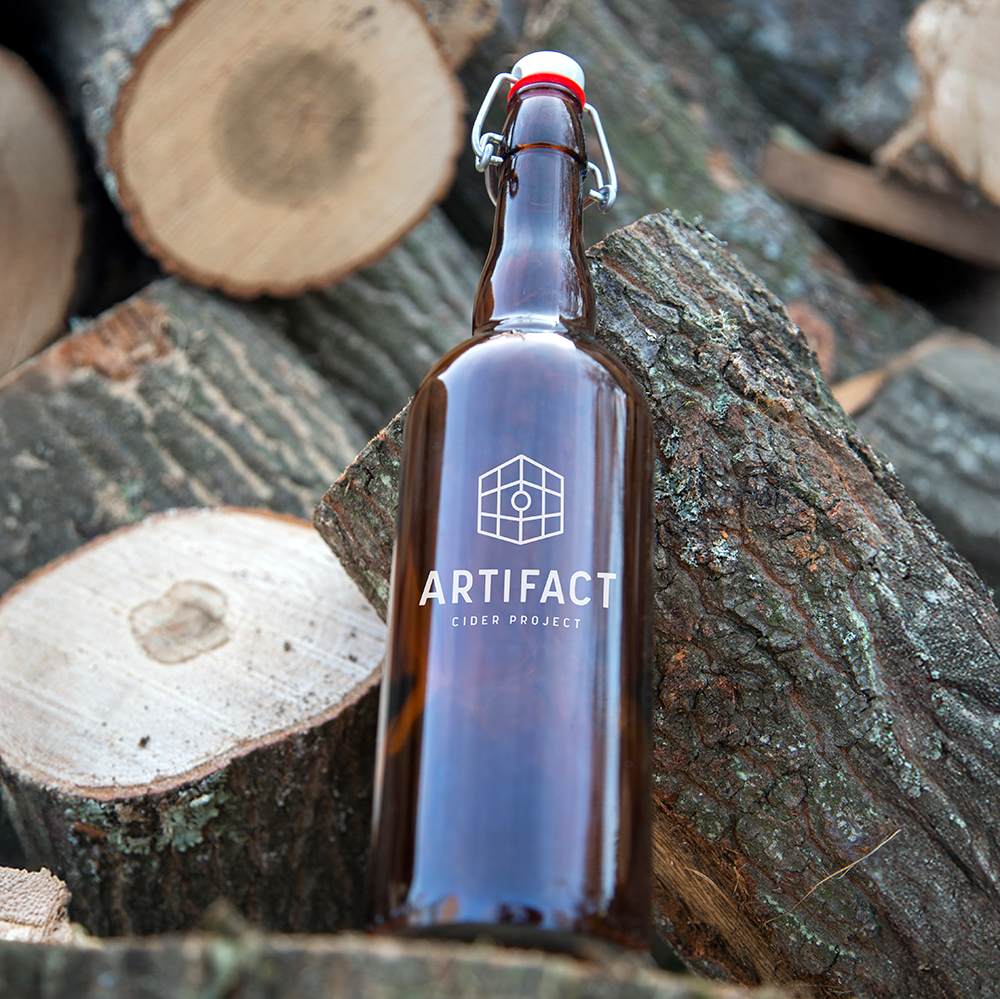 brown-bottle-leans-against-logs-outdoors-2026-09-21-21-27-31-utc.png
