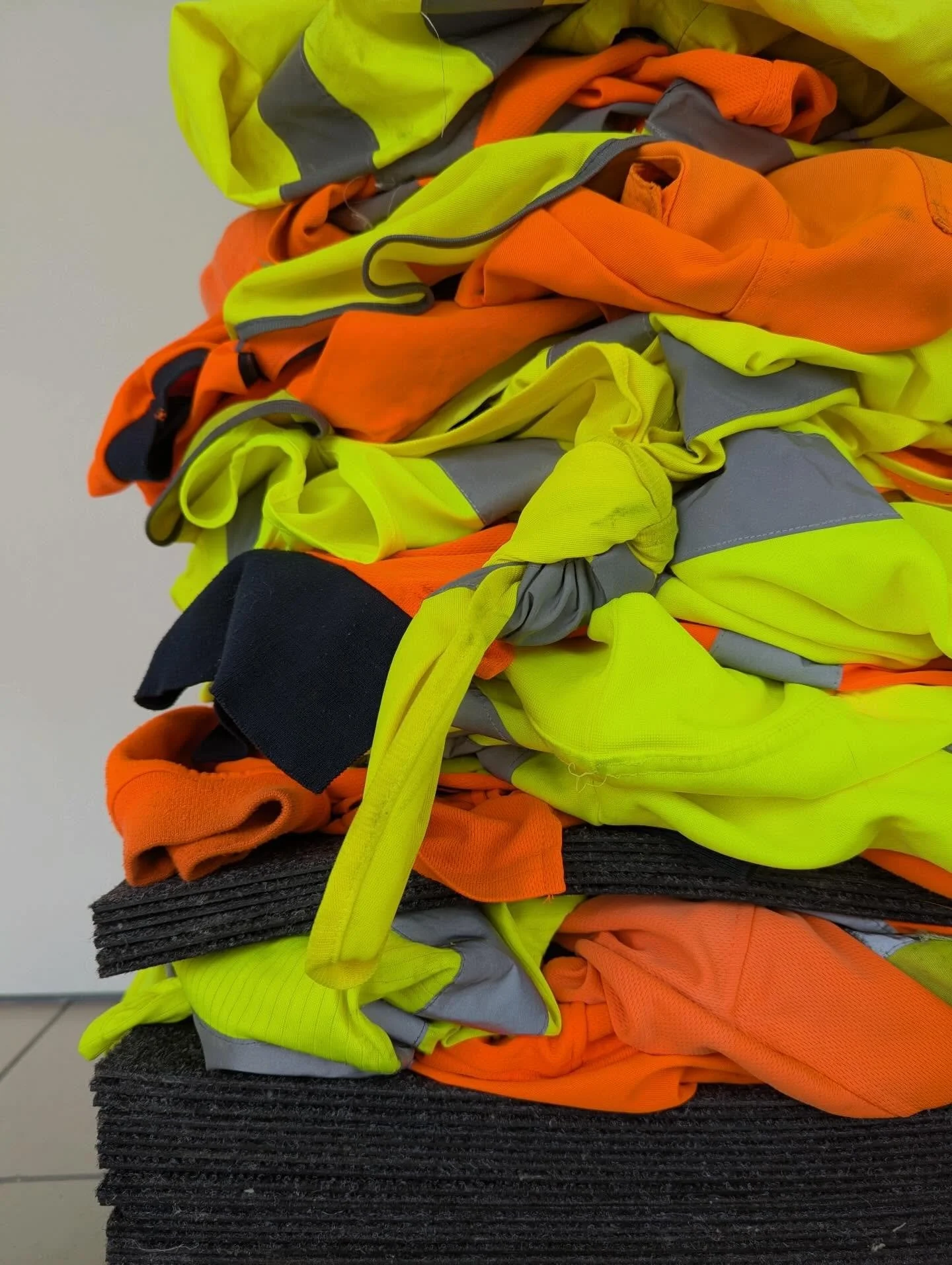 Site Office, 2026. Hi-vis workwear, carpet tiles, pearl sewing pins. @traction.projects 

A series of new forms and repurposed work showing the various states of the hi-vis material that I use. From piled, hung and folded to deconstructed and pinned.