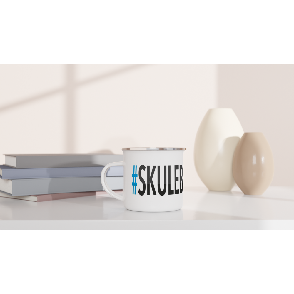 The picture shows a left side view of the 12oz white enamel mug "#SKULEBERGET Höga Kusten" from the series HIKING #TAGMUG™ on a desktop
