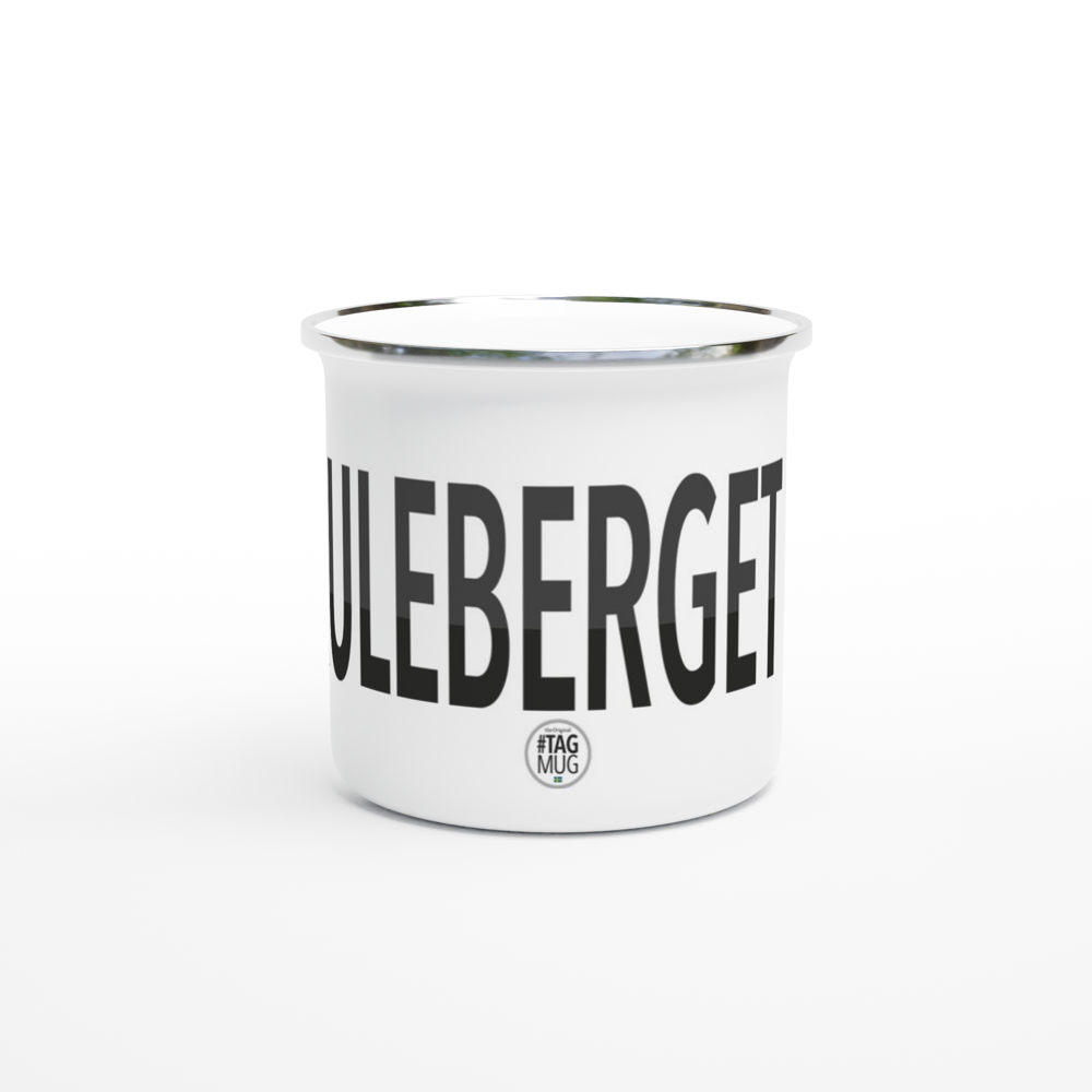 The picture shows the 12oz white enamel mug "#SKULEBERGET Höga Kusten" from the series HIKING #TAGMUG™, taken from the side opposite to the handle