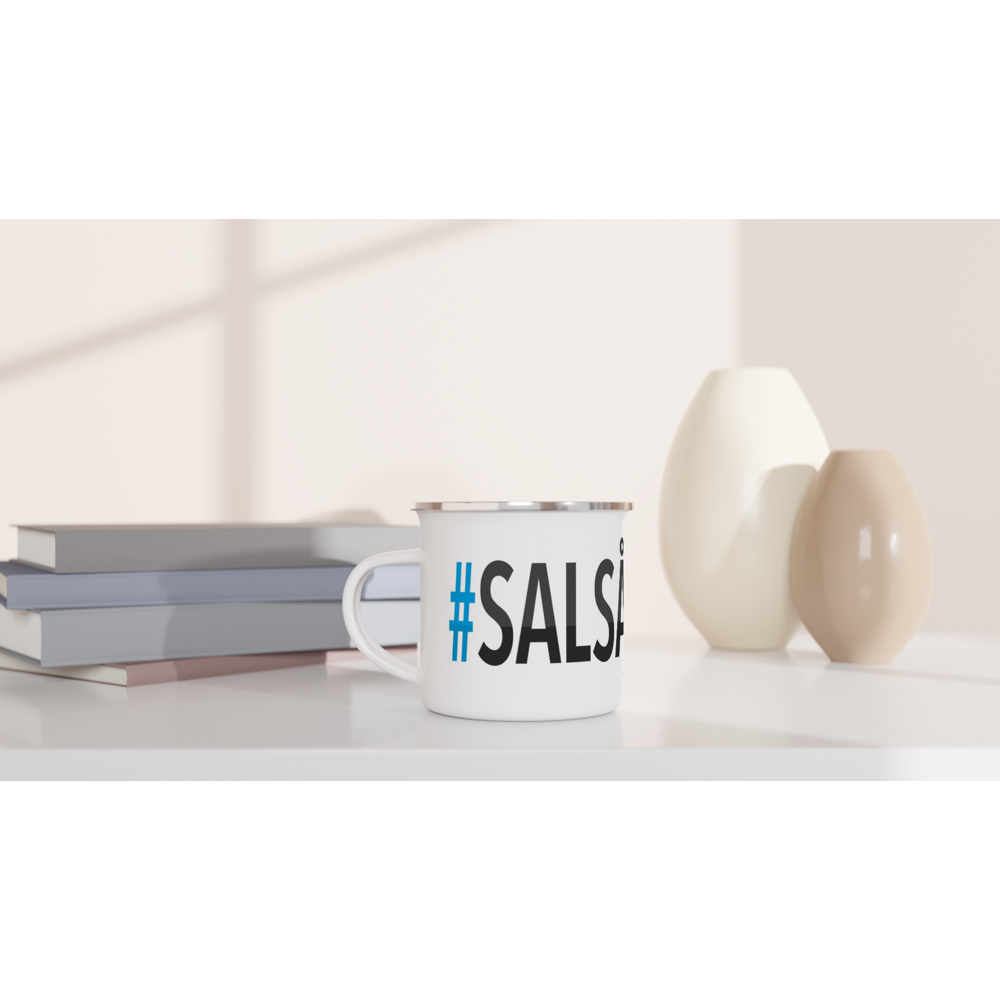 The picture shows a left side view of the 12oz white enamel mug "#SALSÅKER Höga Kusten" from the series HIKING #TAGMUG™ on a desktop