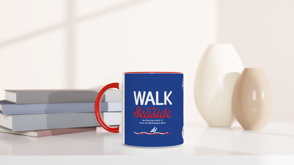 The picture shows a left side view of the 11oz ceramic mug "WALK ON THE SEASIDE" from the series HIGH COAST SAILOR #TAGMUG™ with red color inside on a desktop