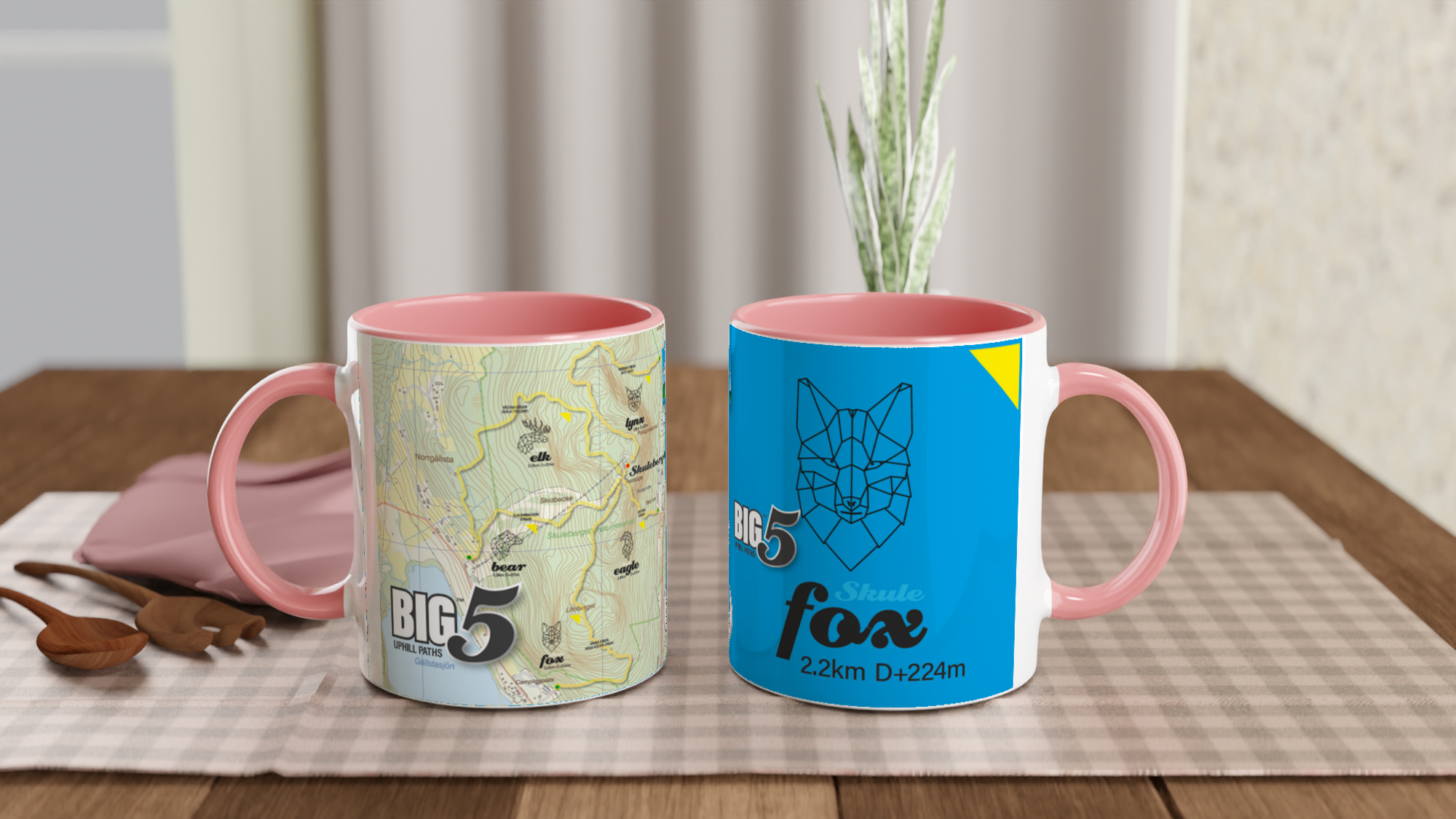 The picture shows the left and right side view of two 11oz ceramic mugs "SKULEBERGET FOX PATH" from the series “SKULE BIG5" #TAGMUG™ with pink color inside