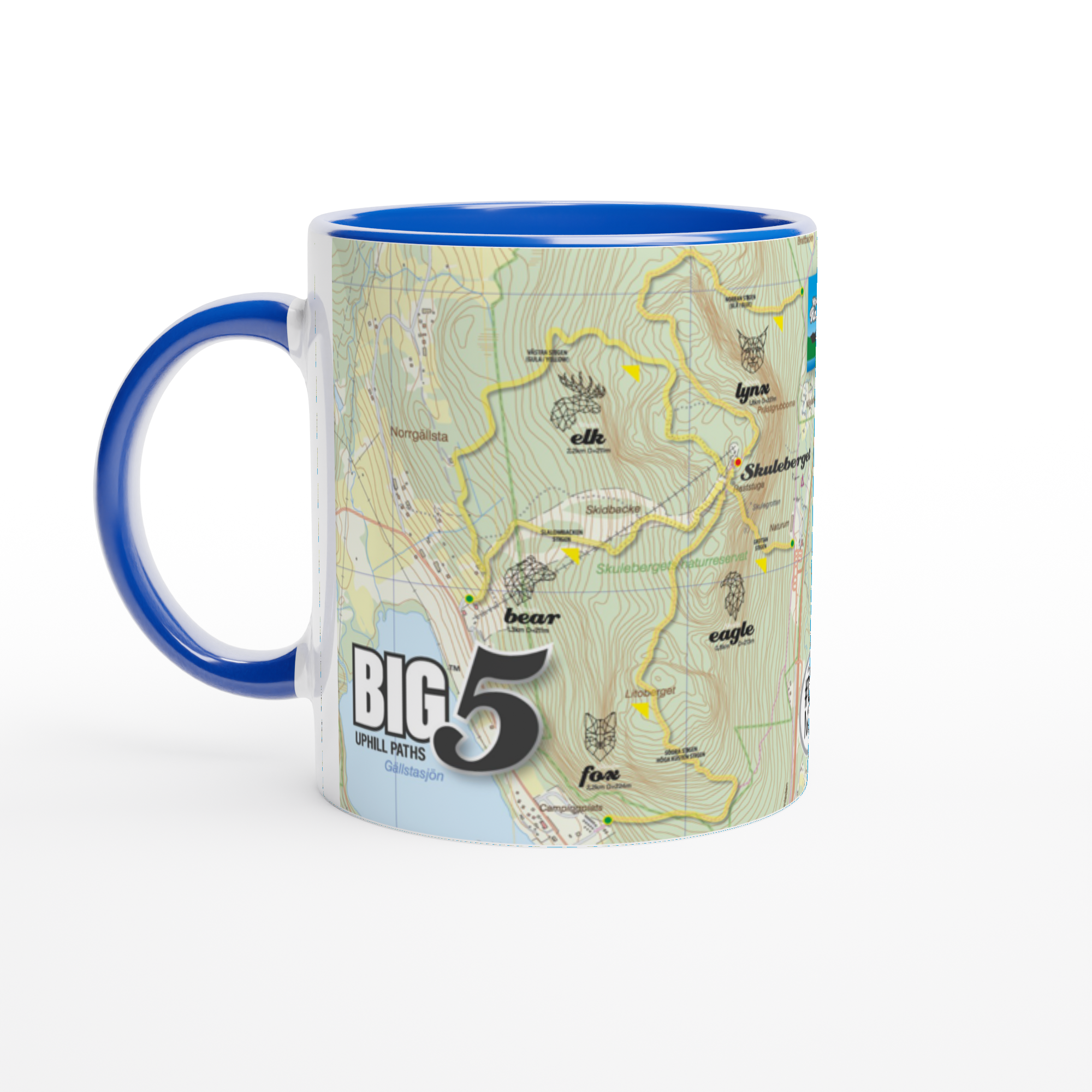 The picture shows a left side view of the 11oz ceramic mug "SKULEBERGET EAGLE PATH" from the series “SKULE BIG5" #TAGMUG™ with blue color inside