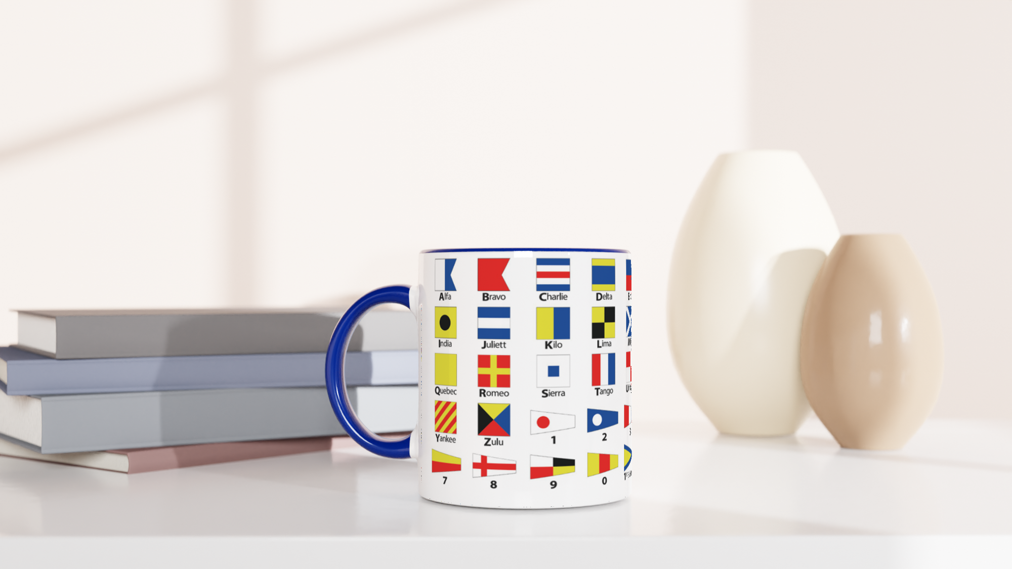 The picture shows a left side view of the 11oz ceramic mug "NAUTICAL FLAGS of the I.c.S.” from the series SAILING #TAGMUG™ with blue color inside on a desktop