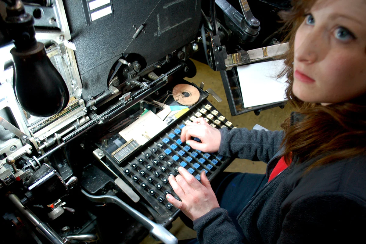 In this meander book workshop, a typography student tries her typing skills on the Intertype's "non-qwerty" keyboard before casting her name in hot metal.