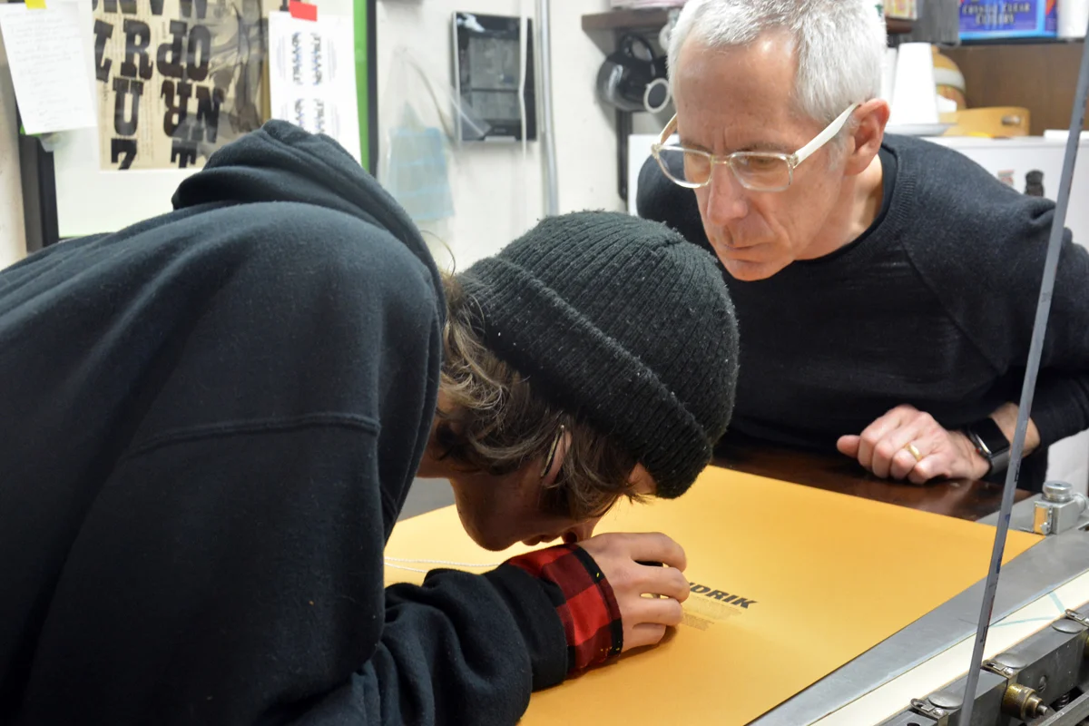 Using a 10x loupe to look at the print quality and ink density.