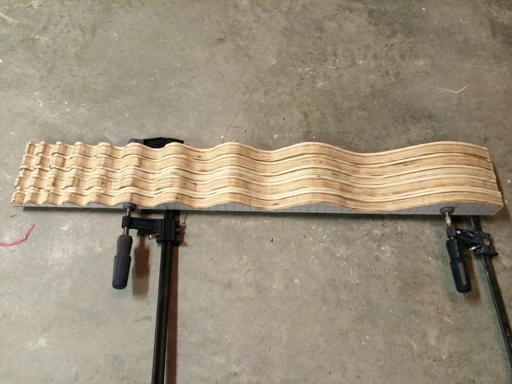 Repeat the pattern-cutting process until enough strips are cut. Apply wood glue to the strips, stack them, and clamp them together. We used different thickneses of wood, and staggered the strips slightly for a unique texture. 