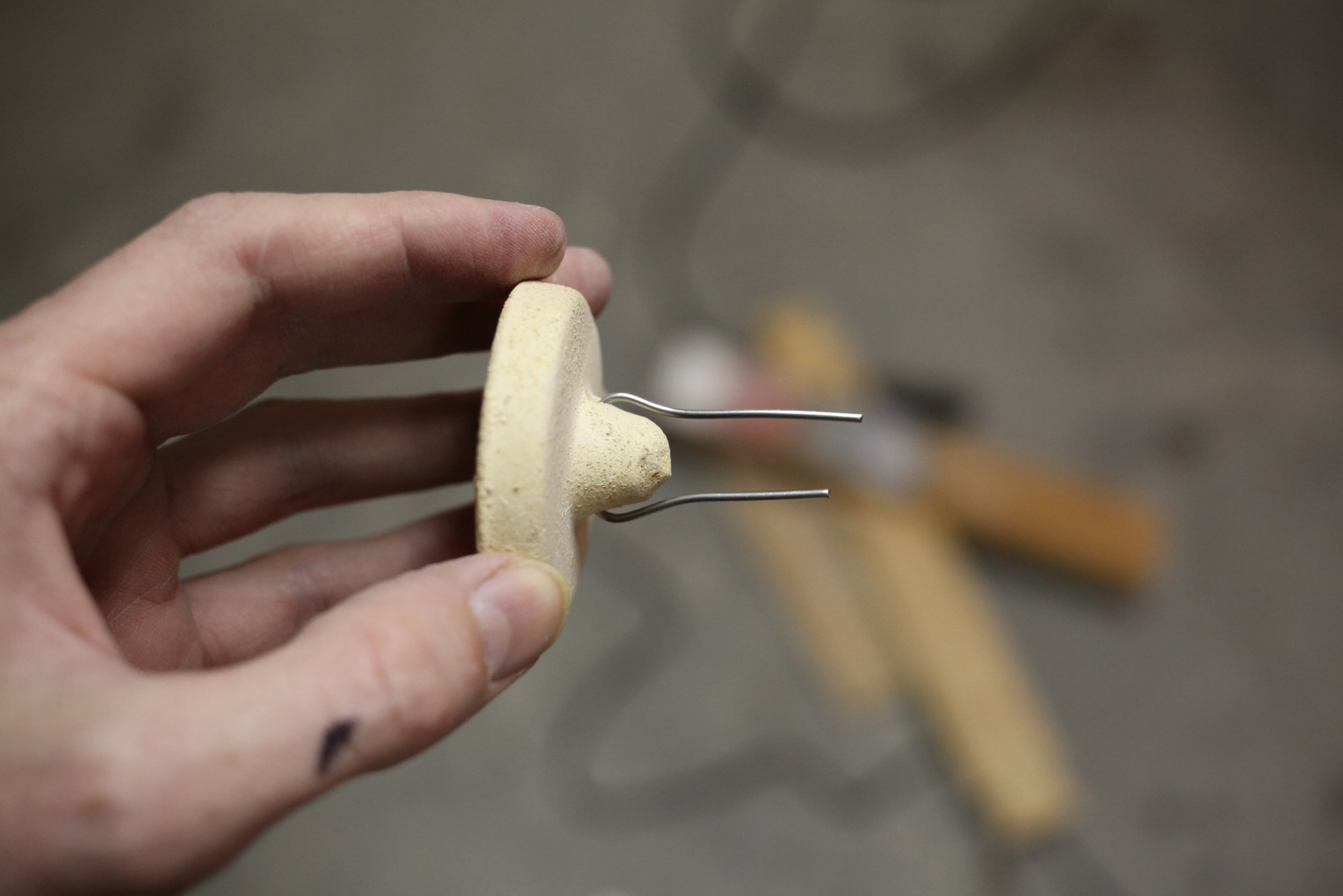 Wire cut and bent to hold a button in place.