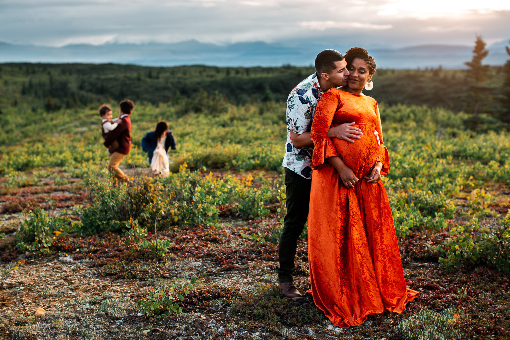 Alaska Family Photographer, couple standing together with children in the background