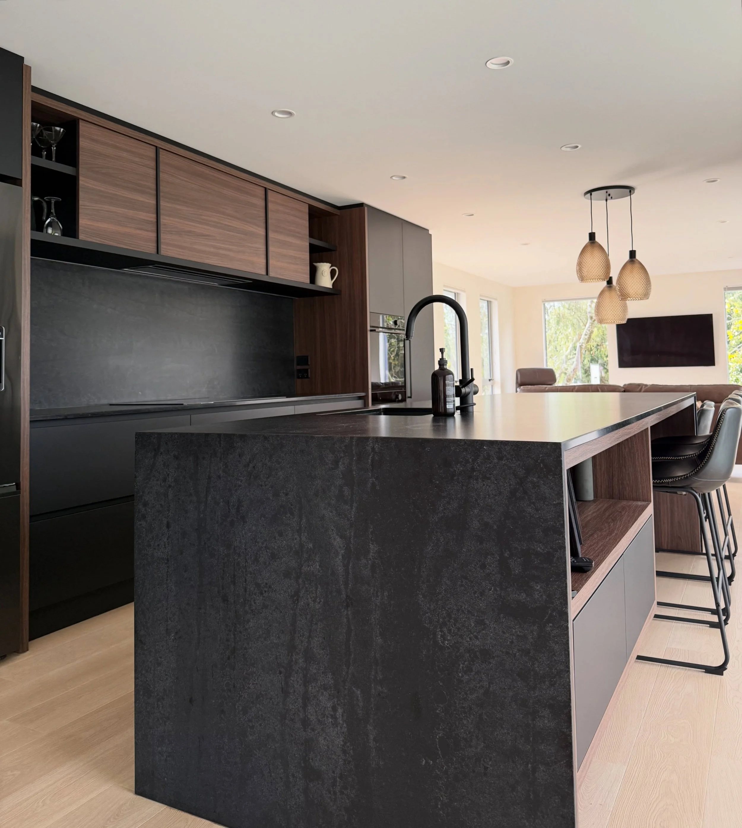 Dark and moody meets light and fresh. This home is a study in contrasts, blonde floors paired with dark walnut. Matte black paired with warm amber lights. Hard and soft; clean lines and heavy texture. You can&rsquo;t see the render on the walls in th