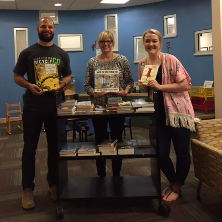 Megan and Adam donating books to Dell Children's Hospital during the Slide UX Goodwill Game.