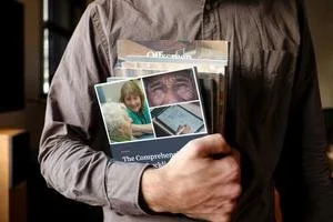 Person holding printed copies of the UX audit checklist guide for AgeTech