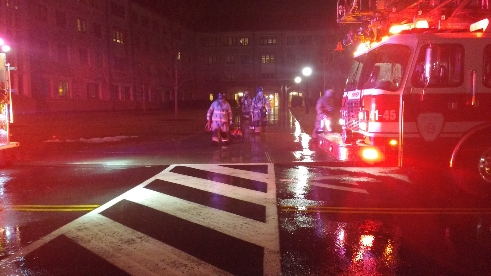 Firefighters walking out of the building, back to their fire trucks.