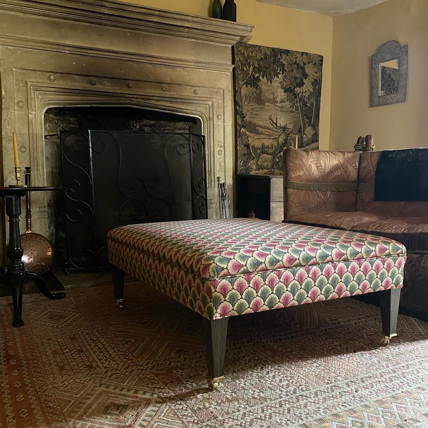 A large Berwick bespoke footstool by Noble. Finished in Walsingham Weave by Flora Soames with the stained tapered legs terminating in brass castors. 

Our footstools can be made in any size with a choice of leg designs and finally finished in a fabri